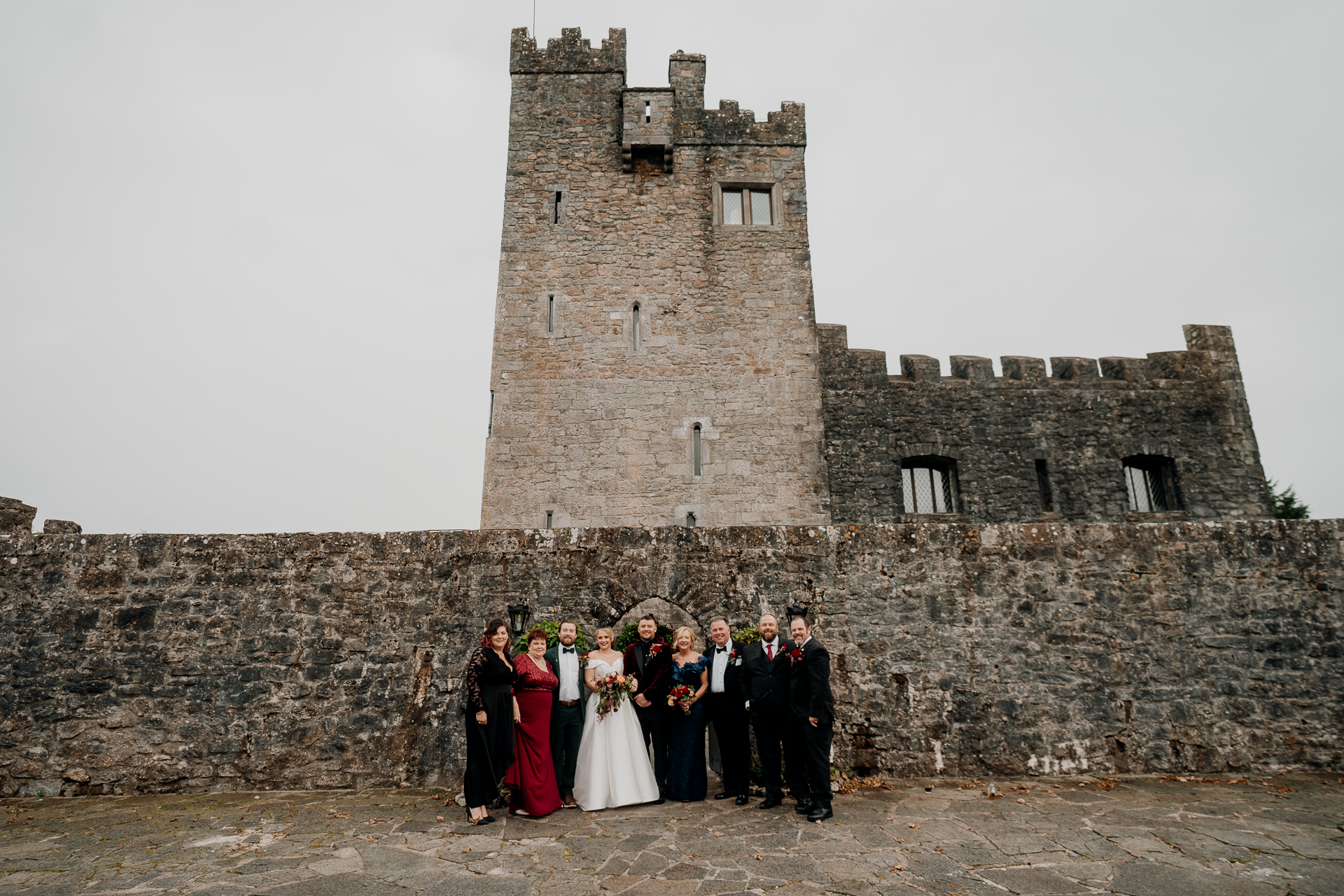 A group of people posing in front of a castle