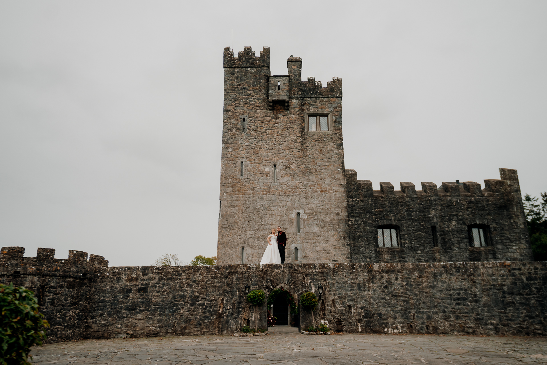 A couple people standing in front of a castle