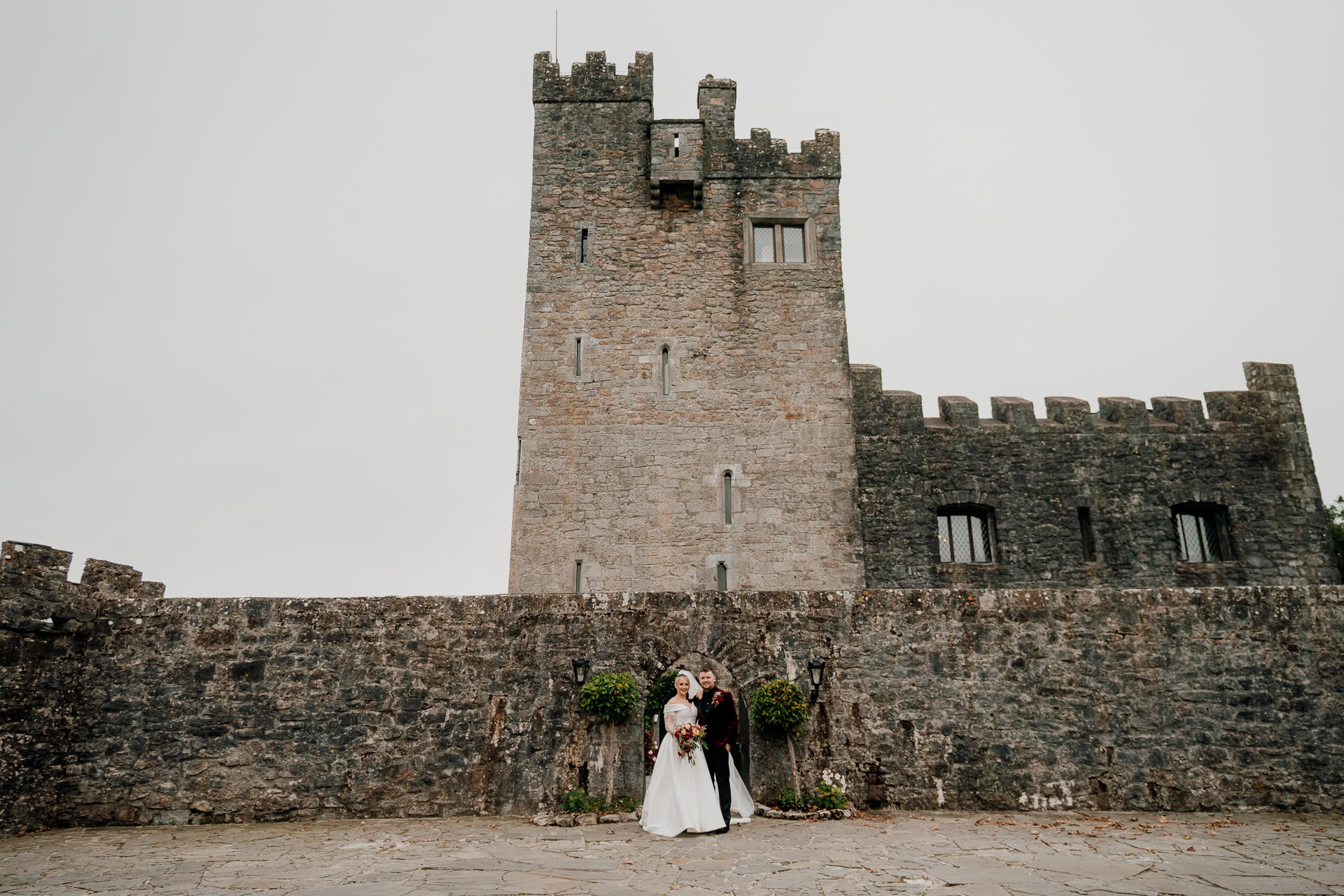 A man and woman in front of a castle