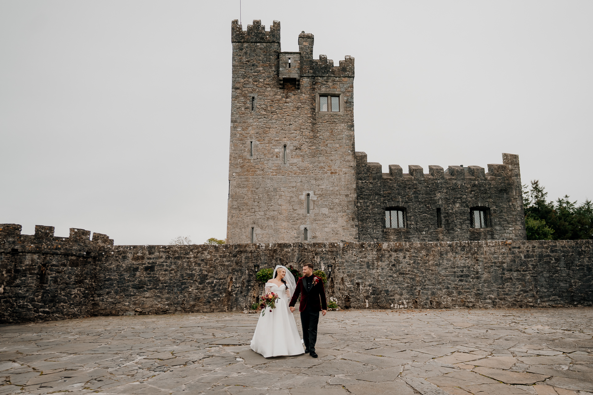 A man and woman in front of a castle