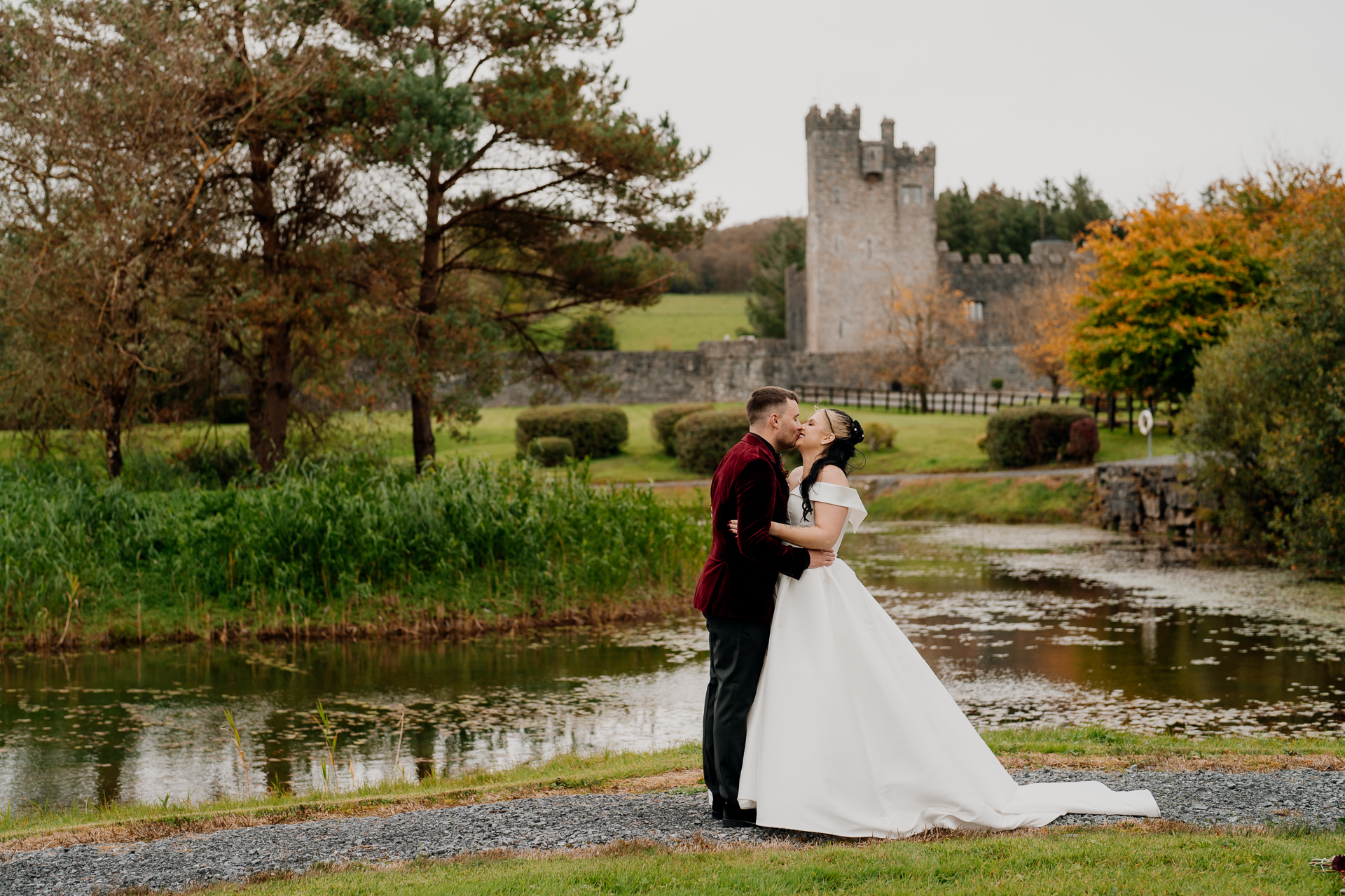 A man and woman kissing in front of a castle