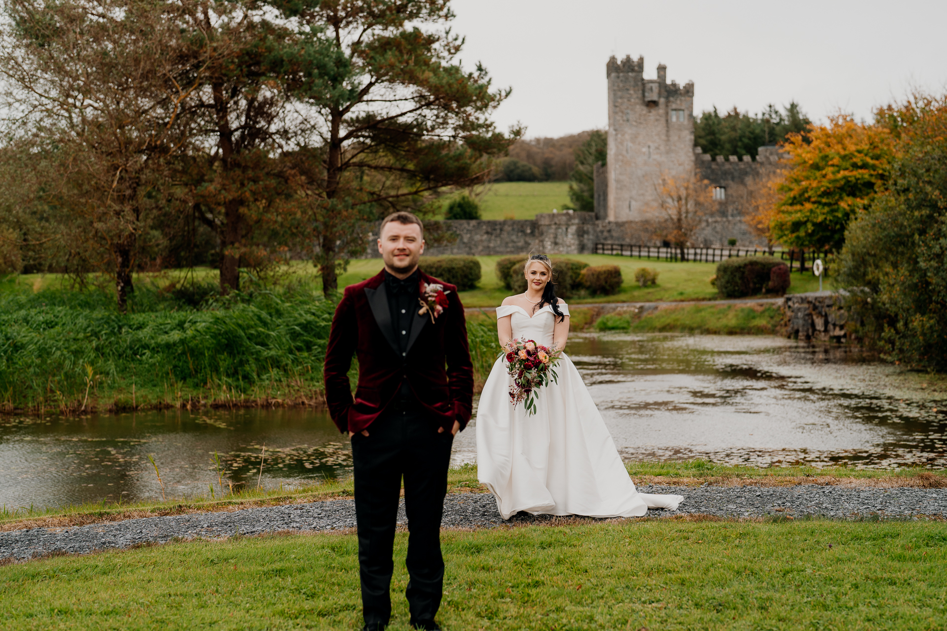 A man and woman posing for a picture in front of a pond