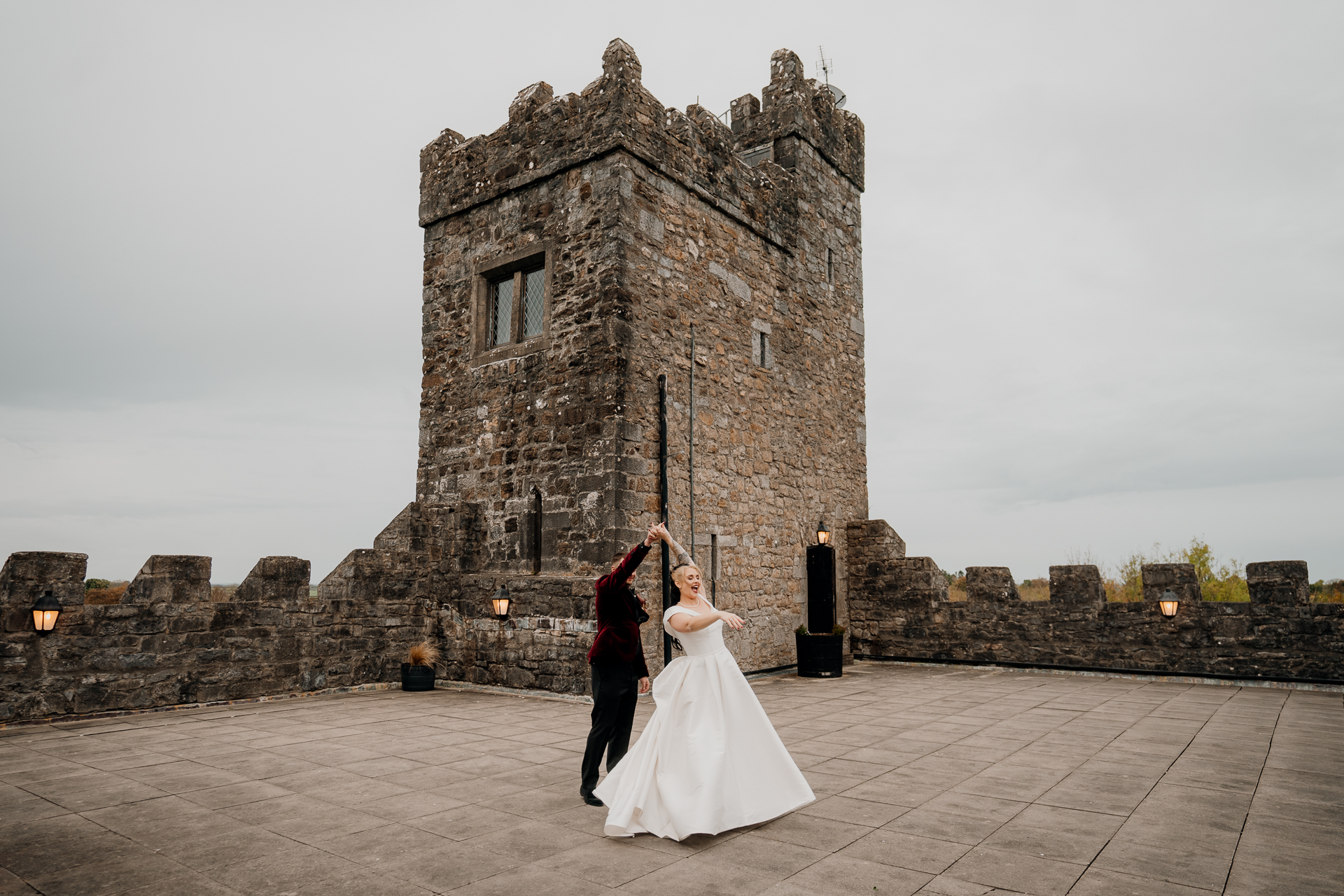 A man and woman in front of a castle