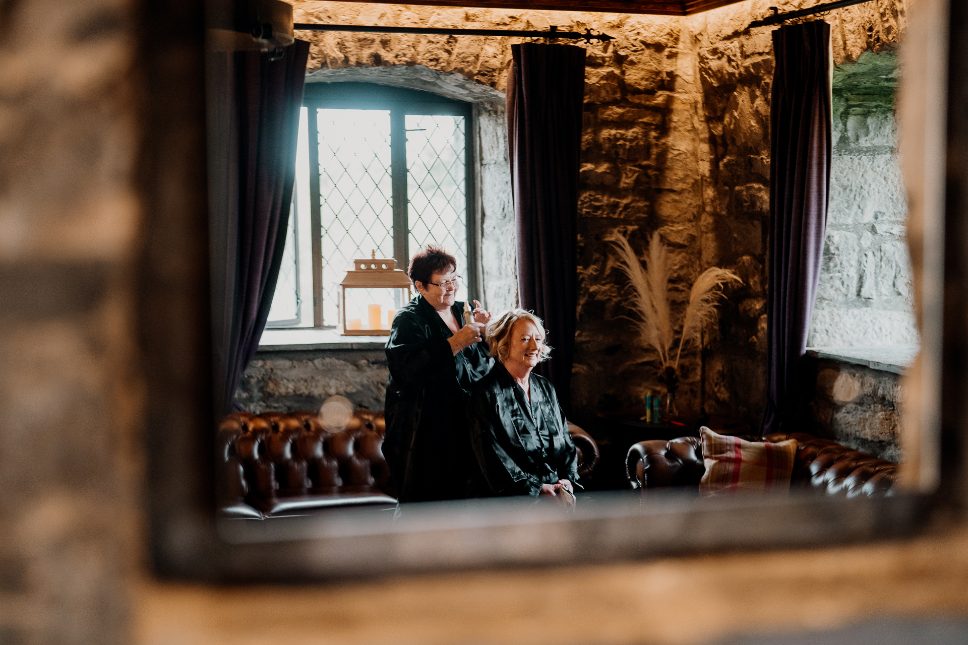 A man and woman sitting on a bench in a room with a window