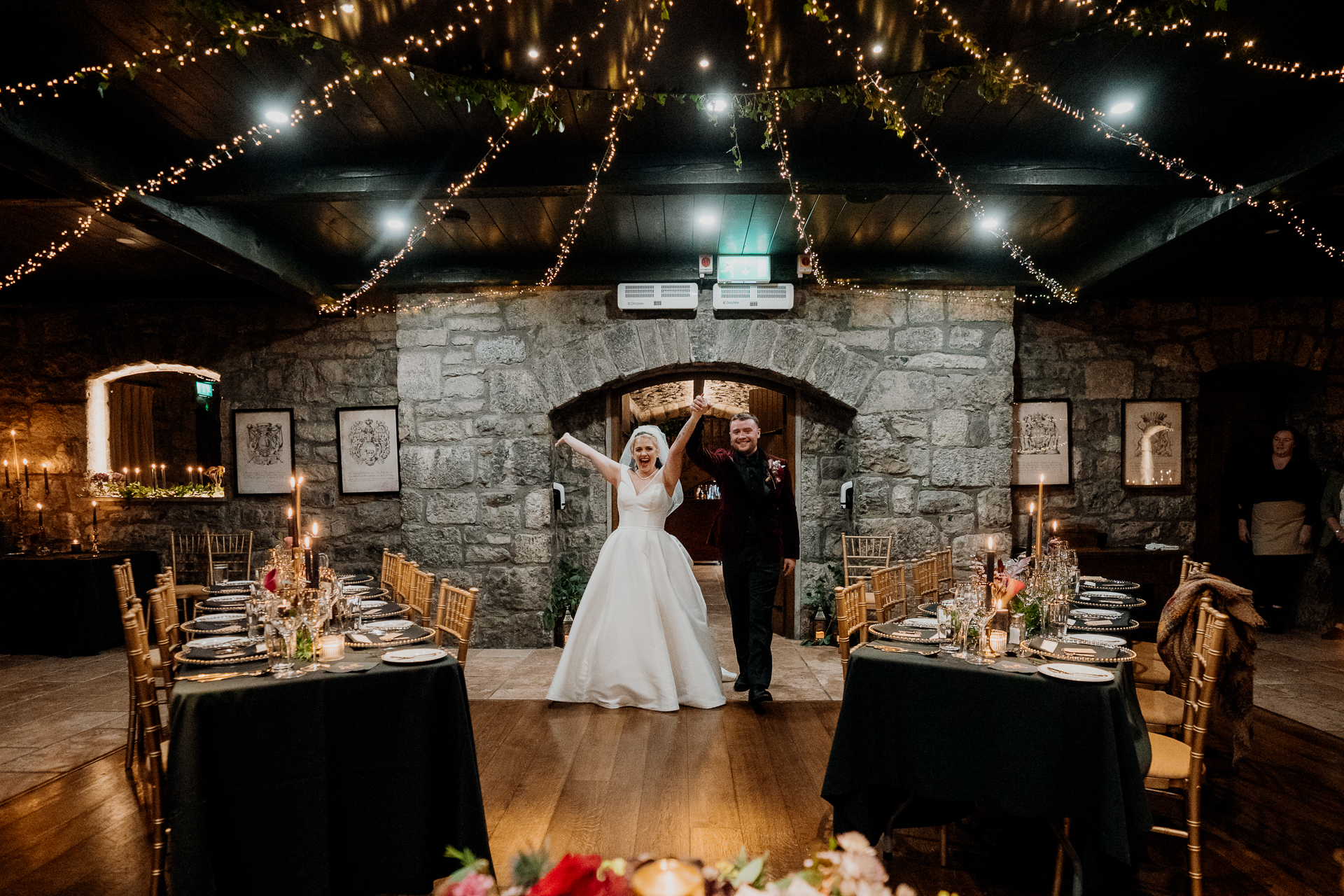 A man and woman in a room with tables and chairs and a chandelier