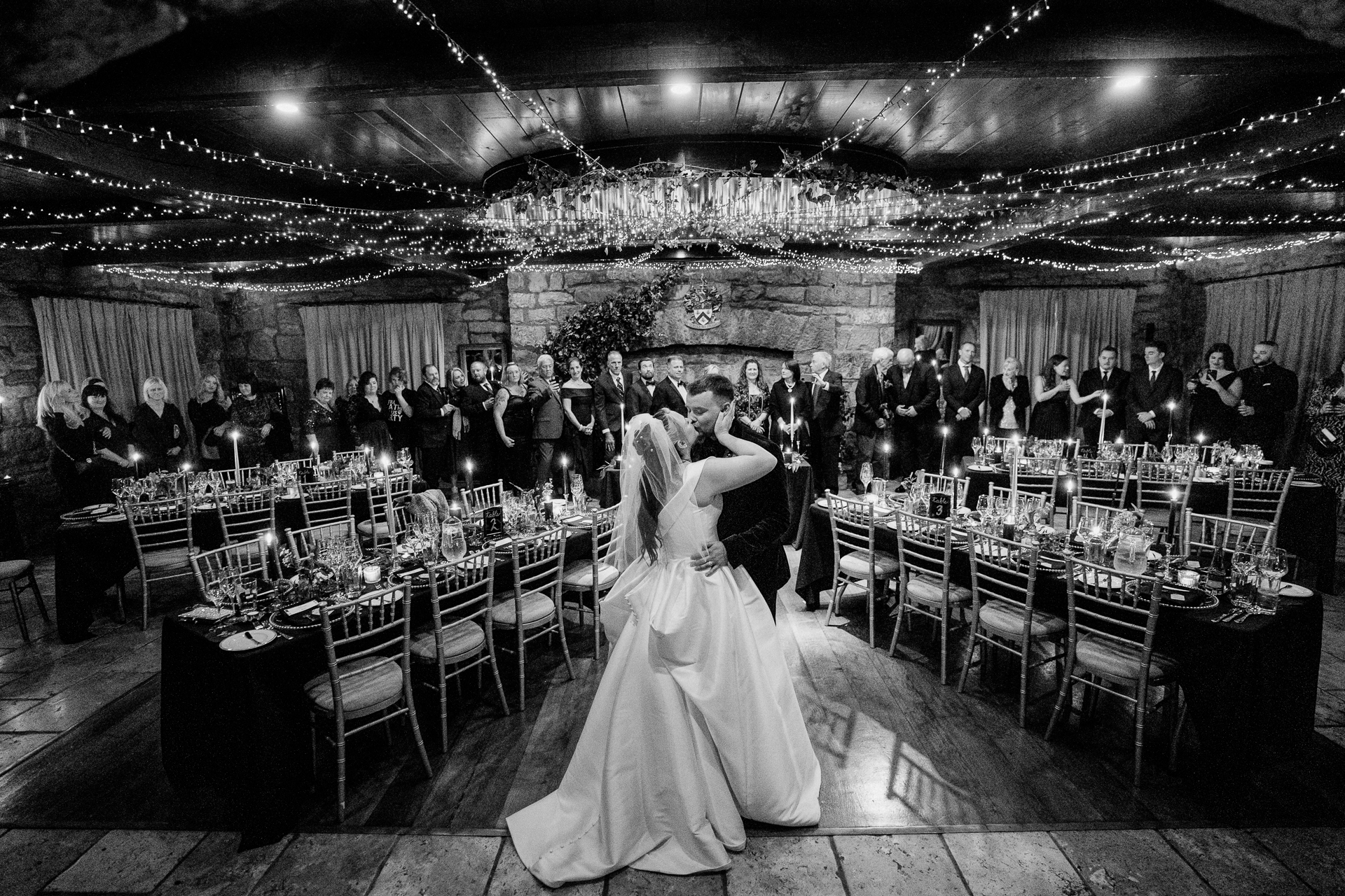 A man and woman dancing in a room full of tables and chairs