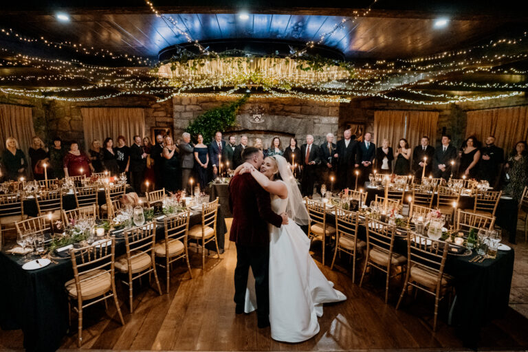 A man and woman kissing in a room full of people