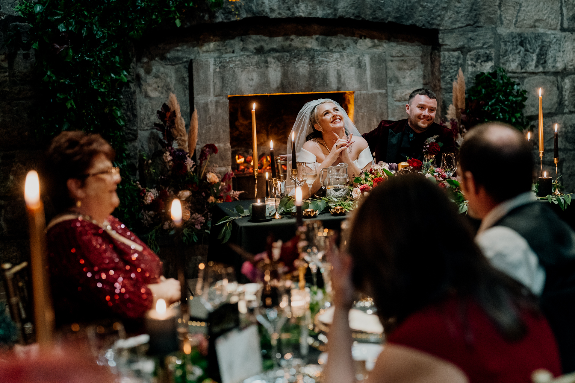 A group of people sitting around a table with candles