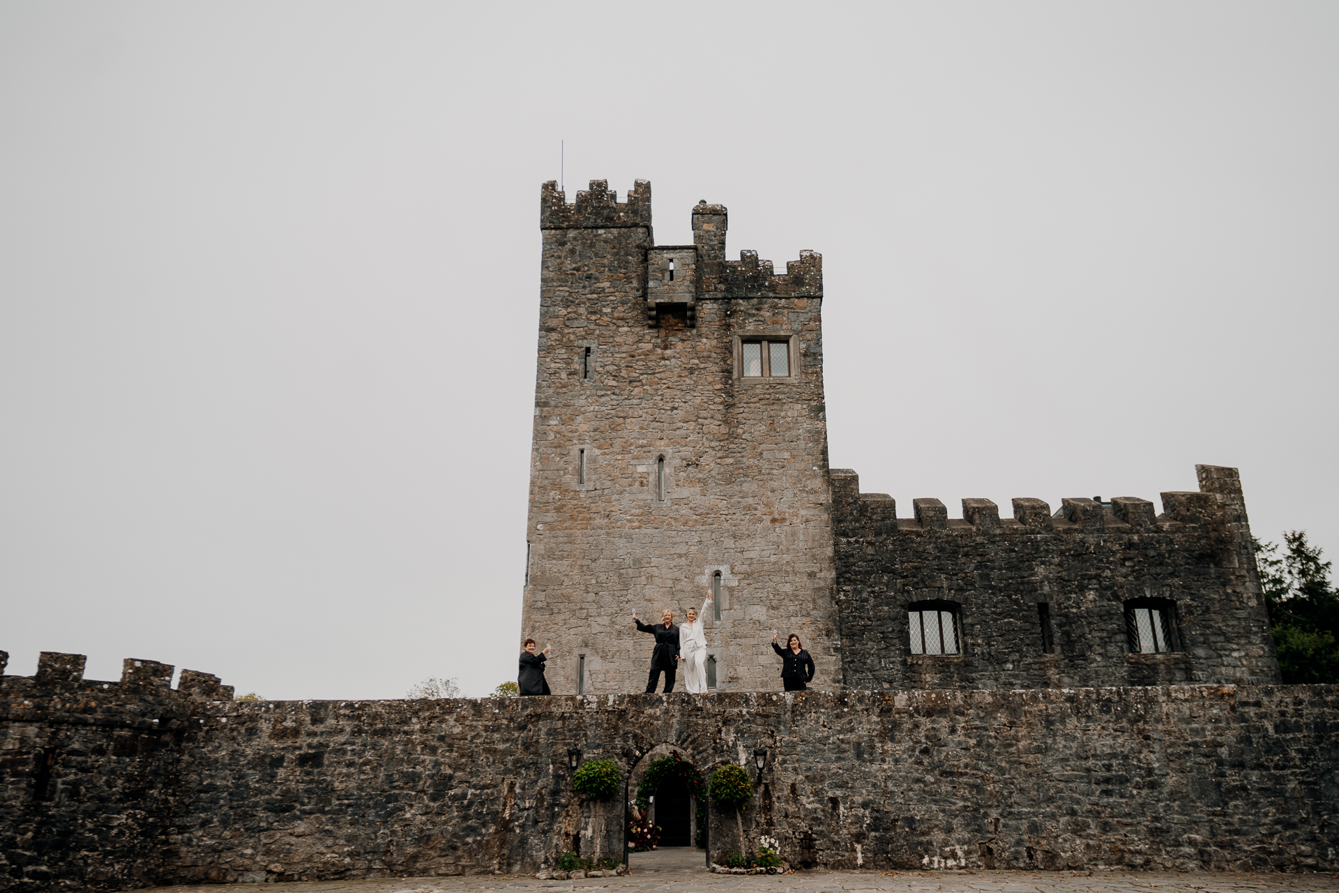 A stone castle with people standing on the side