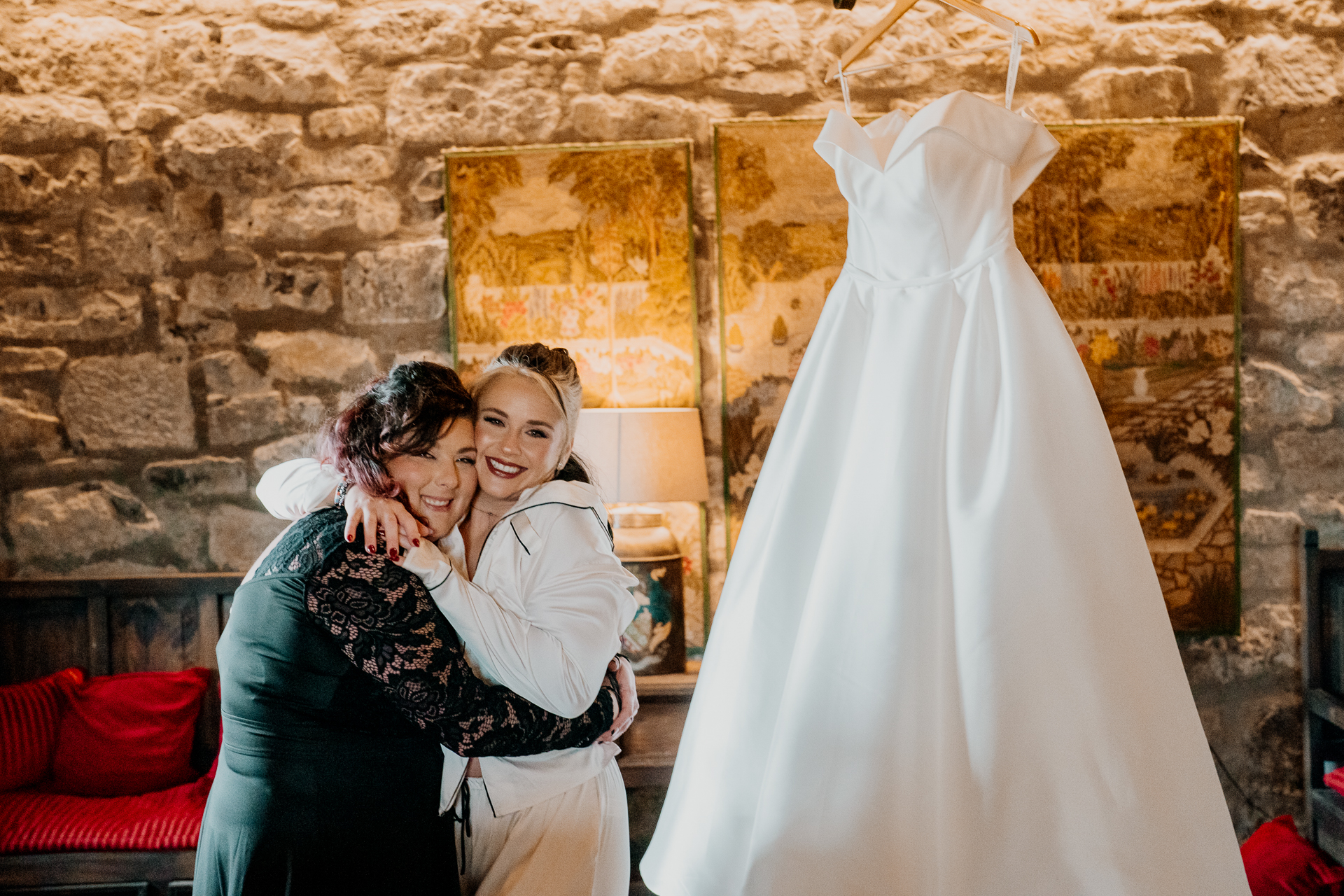 A person in a white dress hugging a person in a black dress