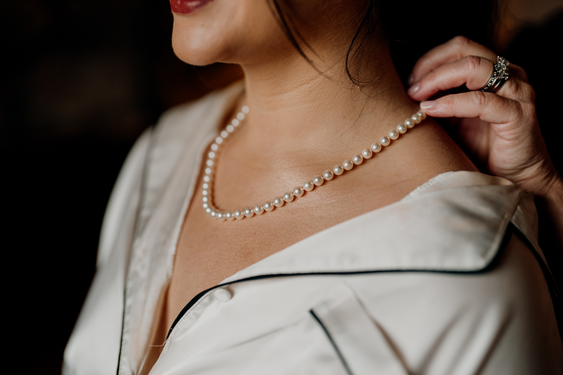 A woman wearing a white shirt and gold necklace