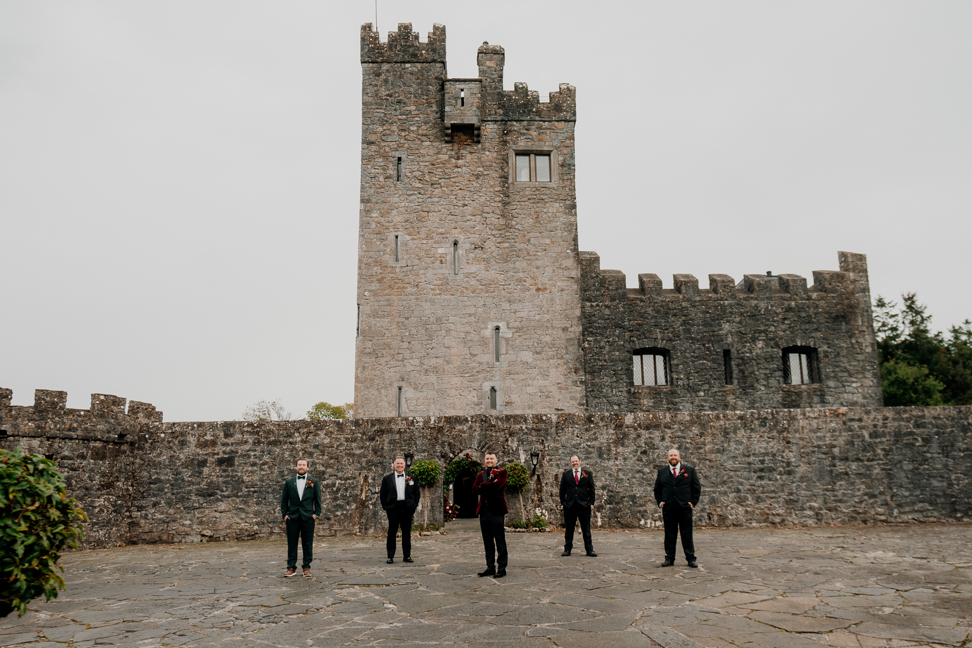 A group of people standing in front of a stone castle