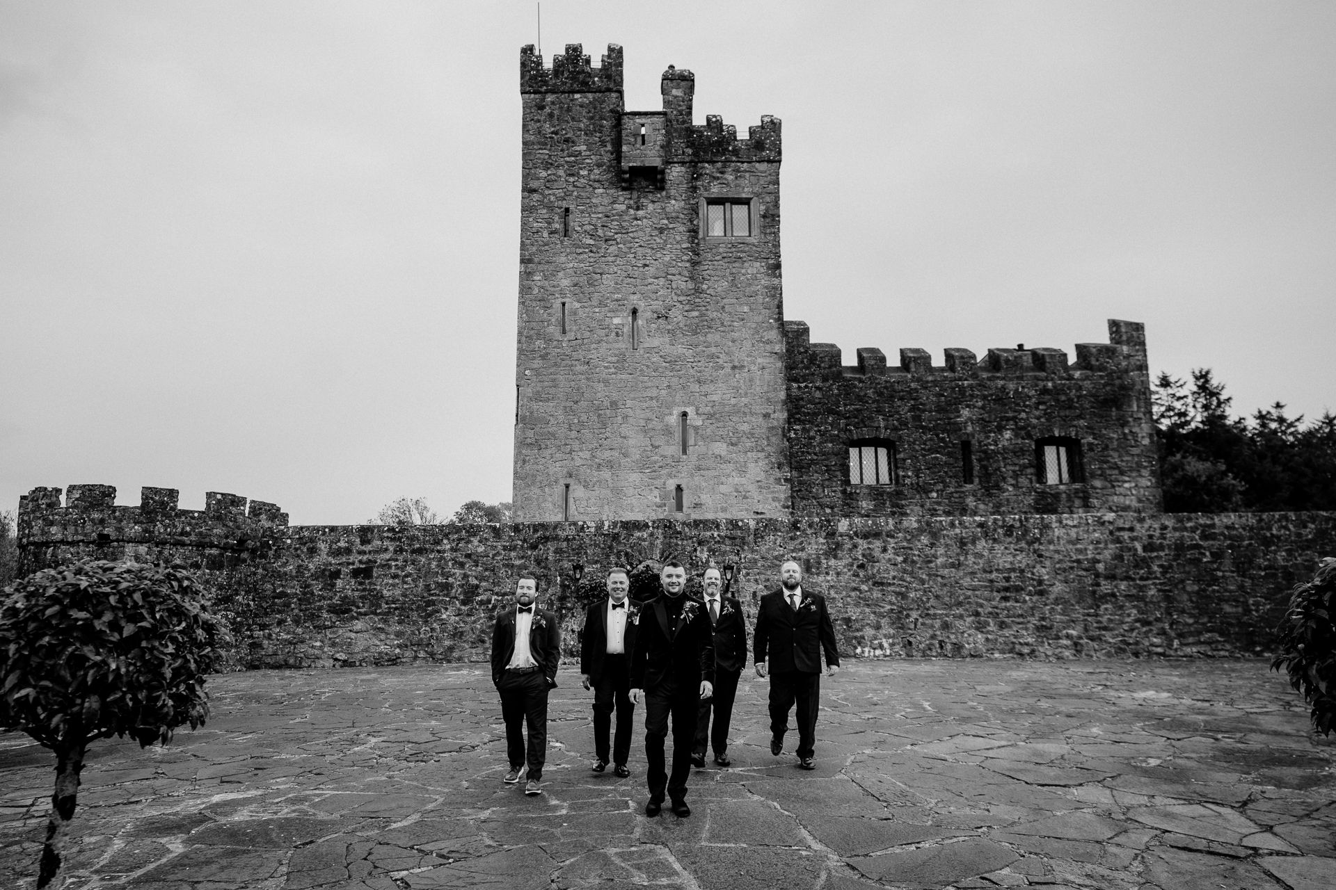 A group of people standing in front of a stone building