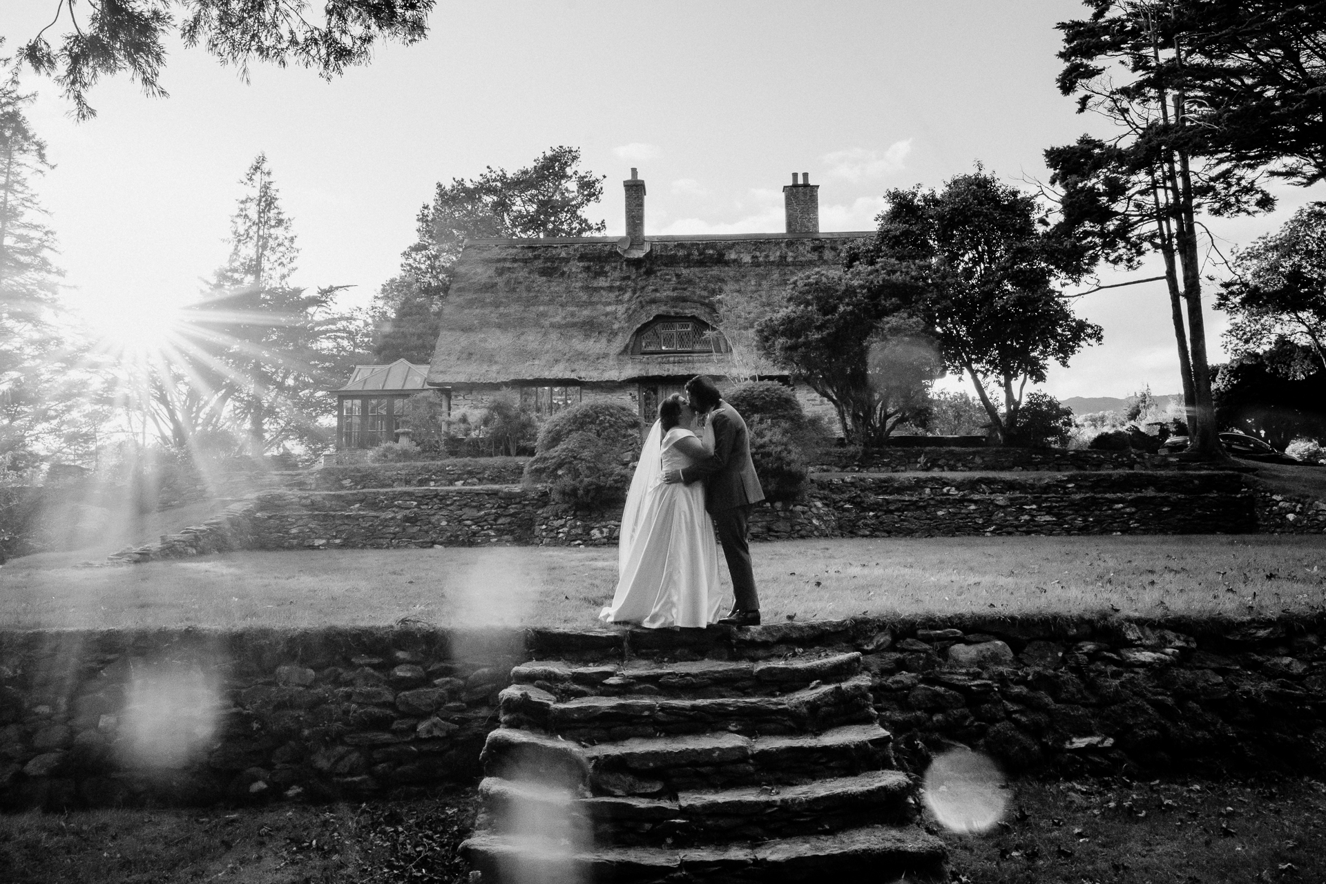 A man and woman kissing in front of a house