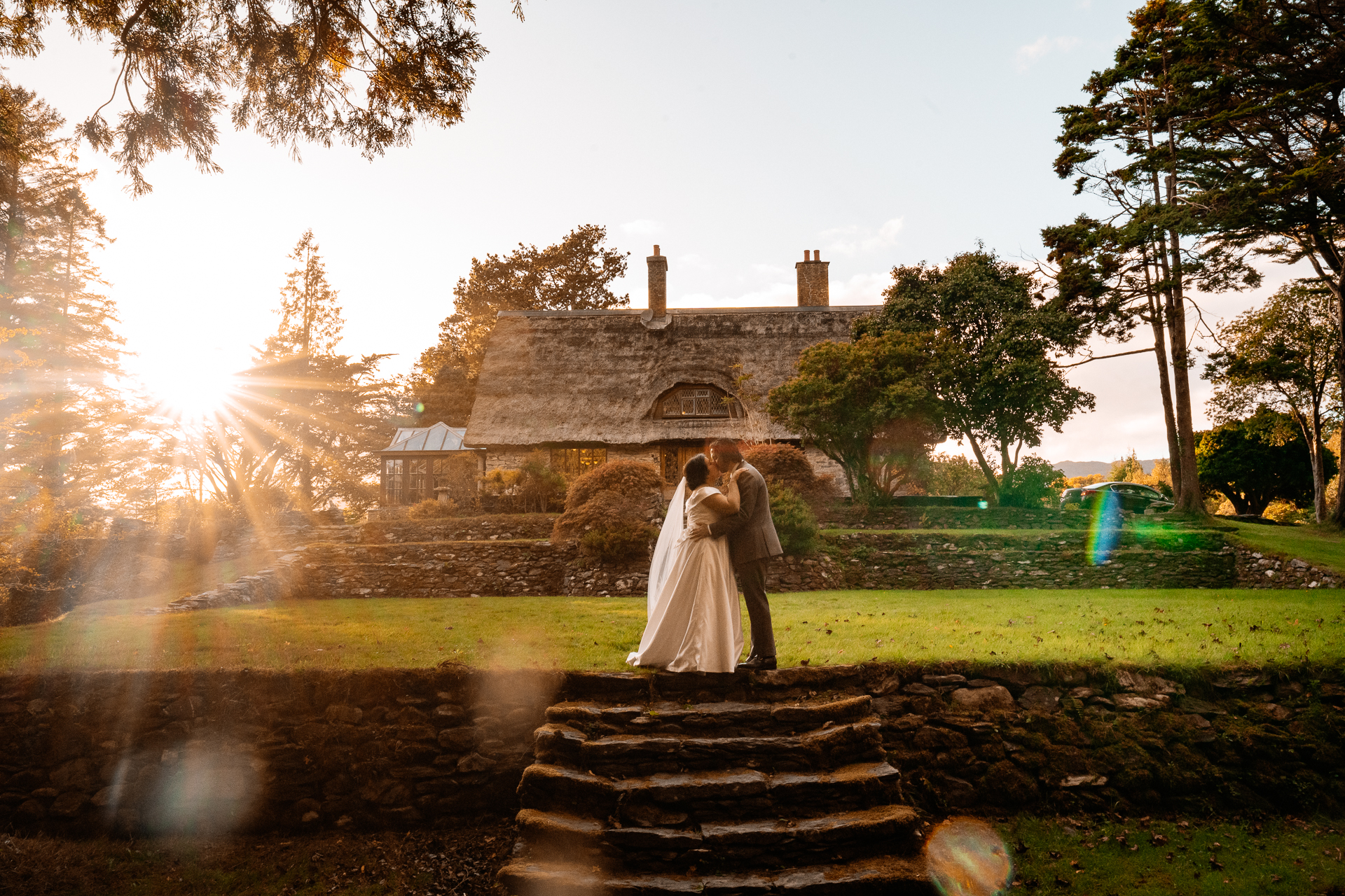 A man and woman kissing in front of a house