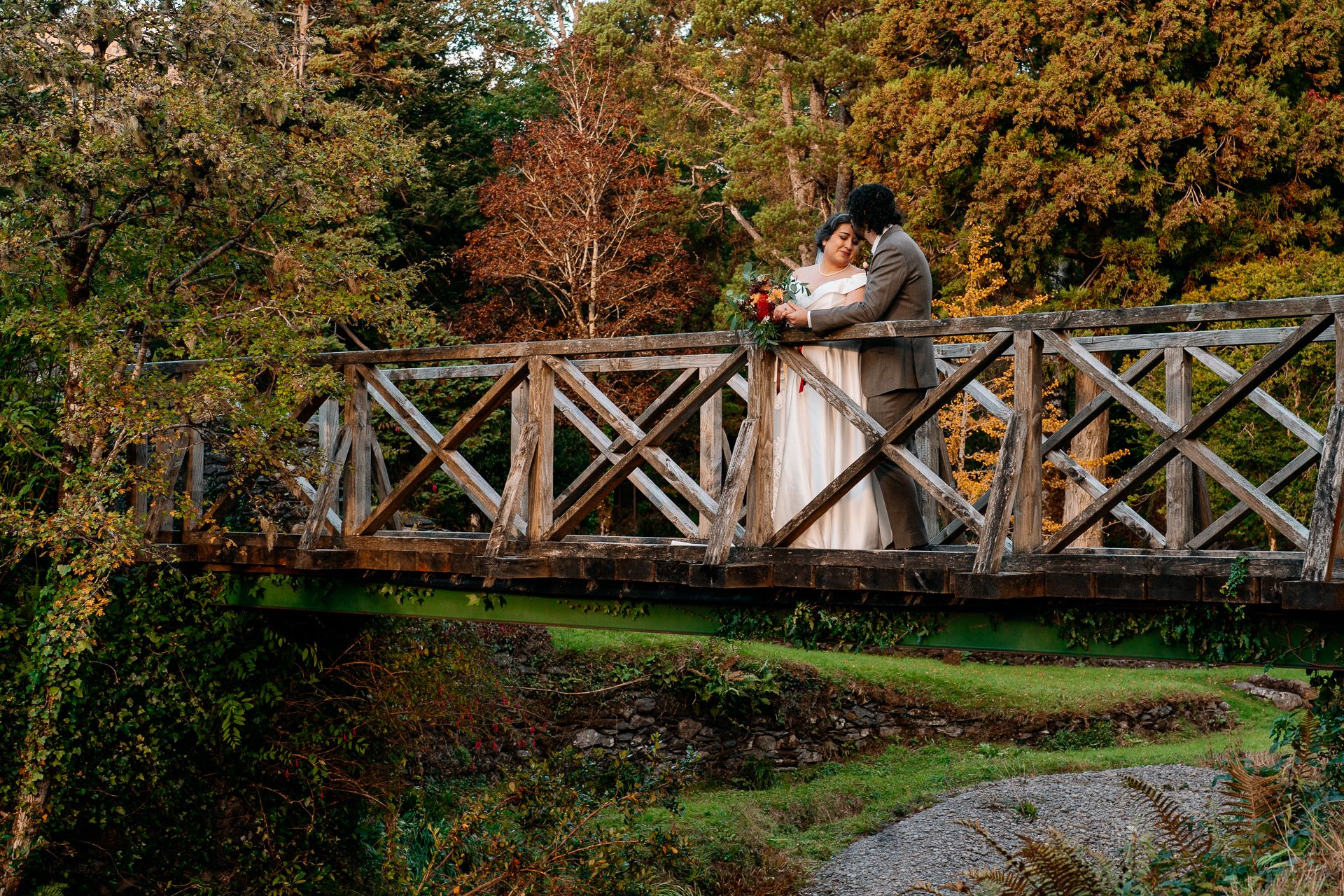 A man and woman kissing on a bridge