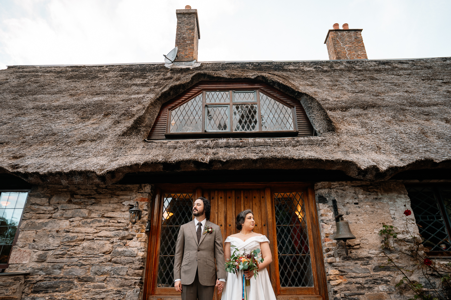 A man and woman standing in front of a house