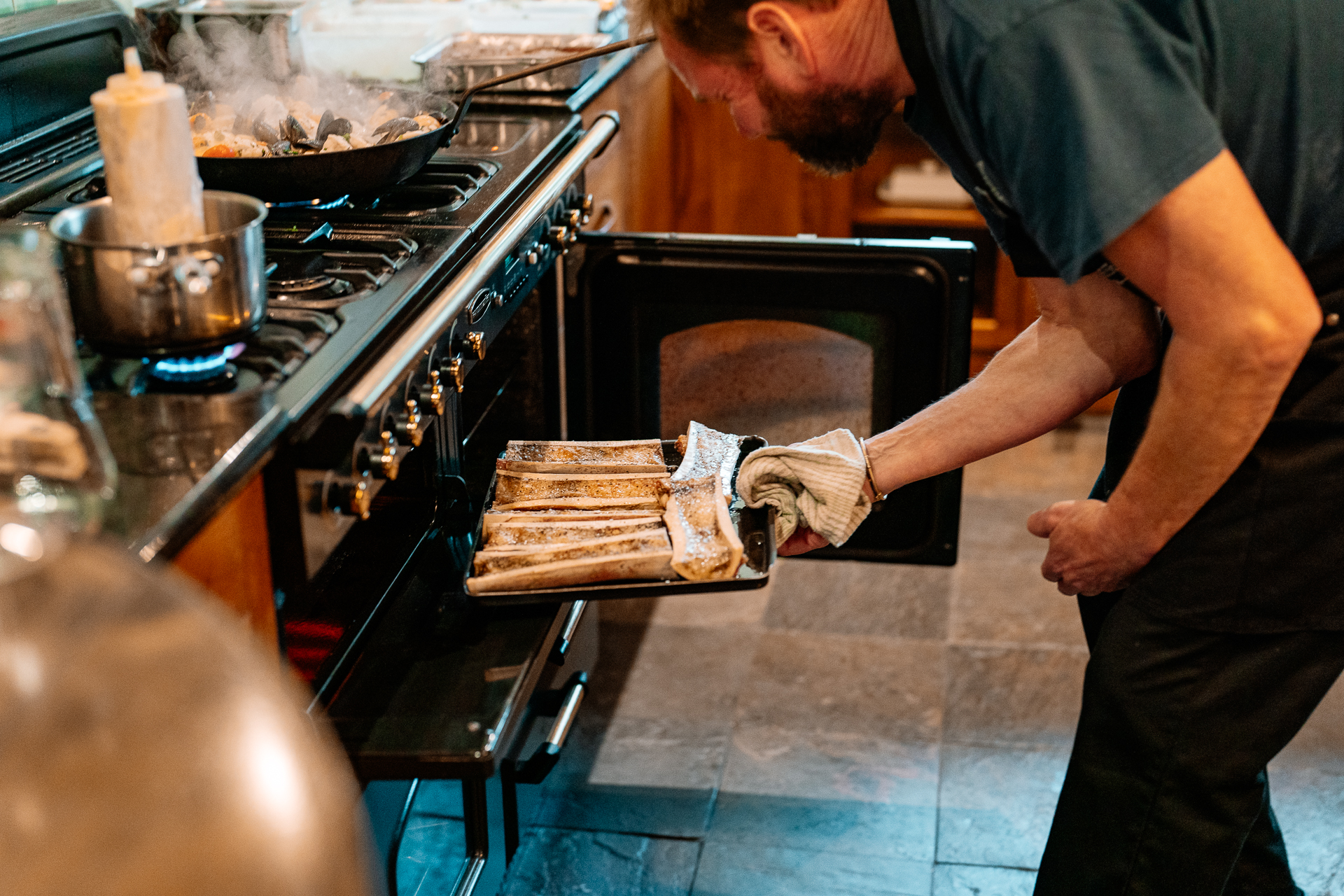 A man putting a pizza in an oven