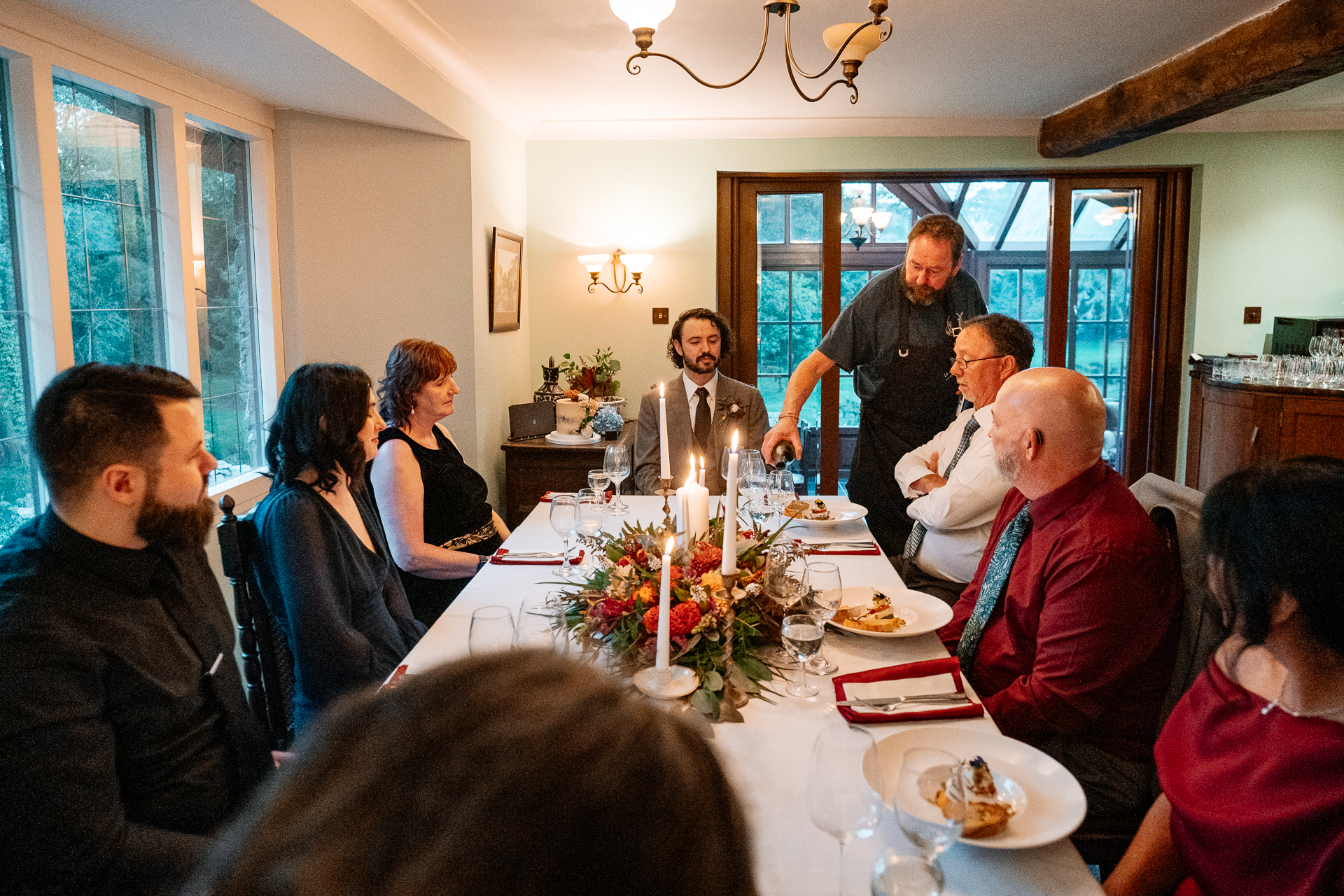 A group of people sitting around a table with food and drinks