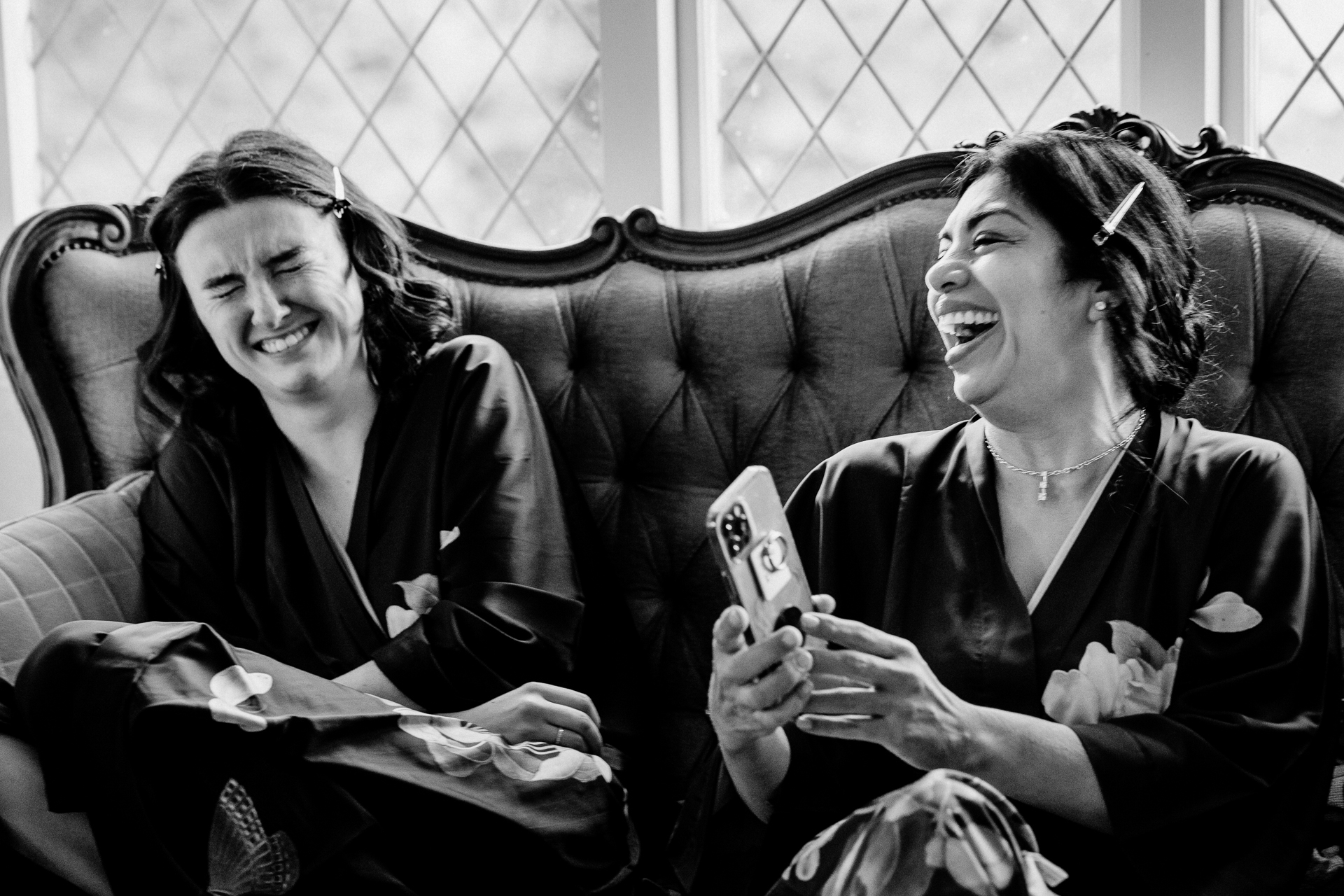 A couple of women sitting on a couch and laughing