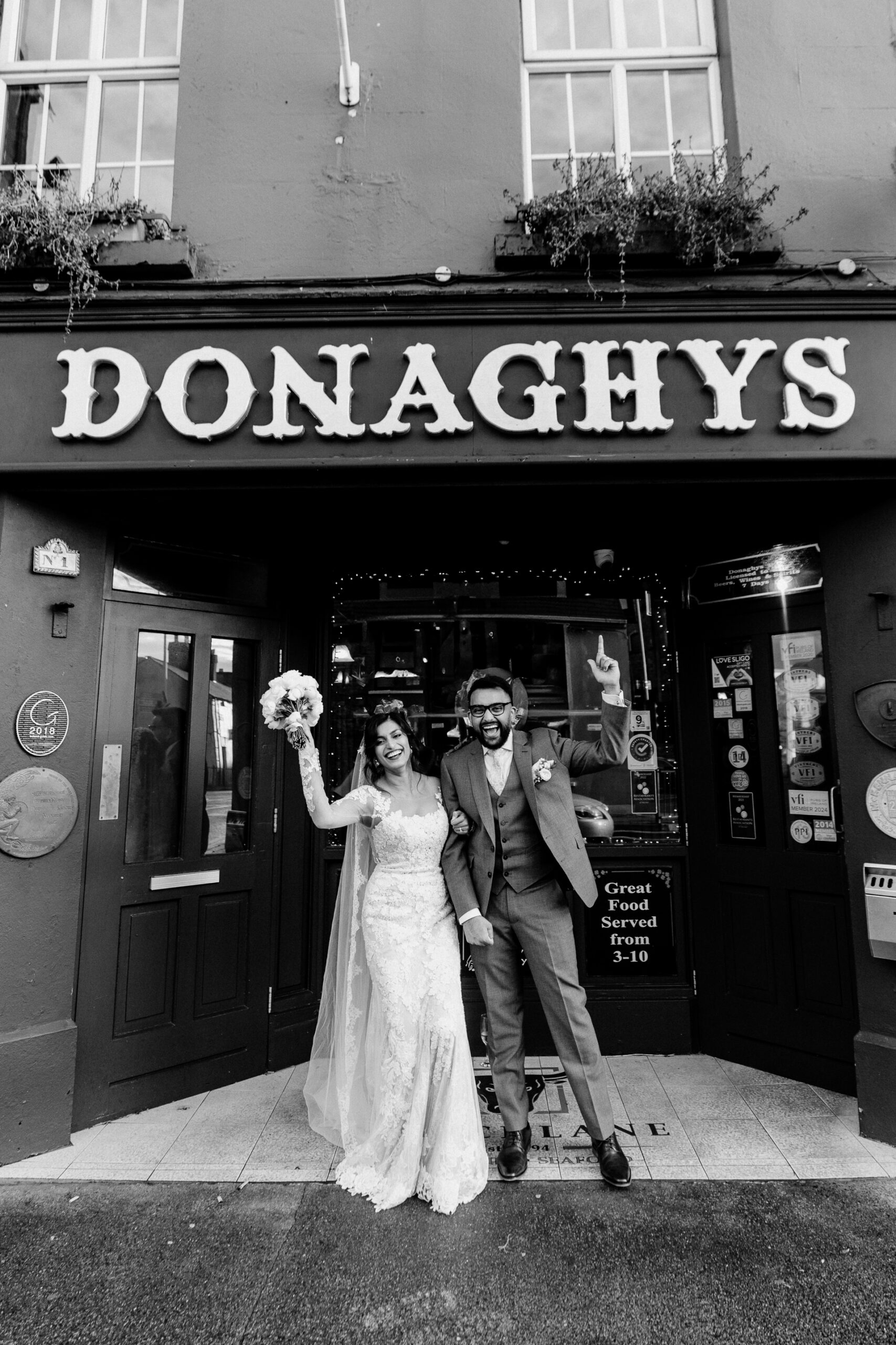 A man and woman in wedding attire standing in front of a store