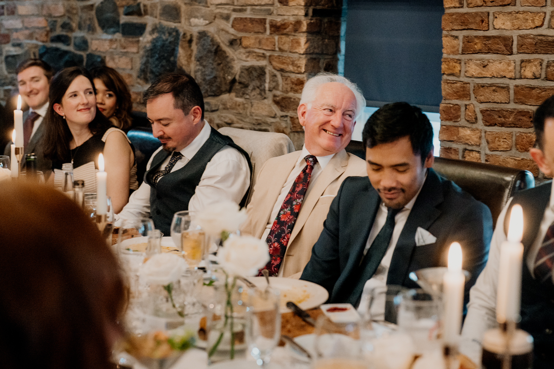 A group of people sitting around a table with food and drinks