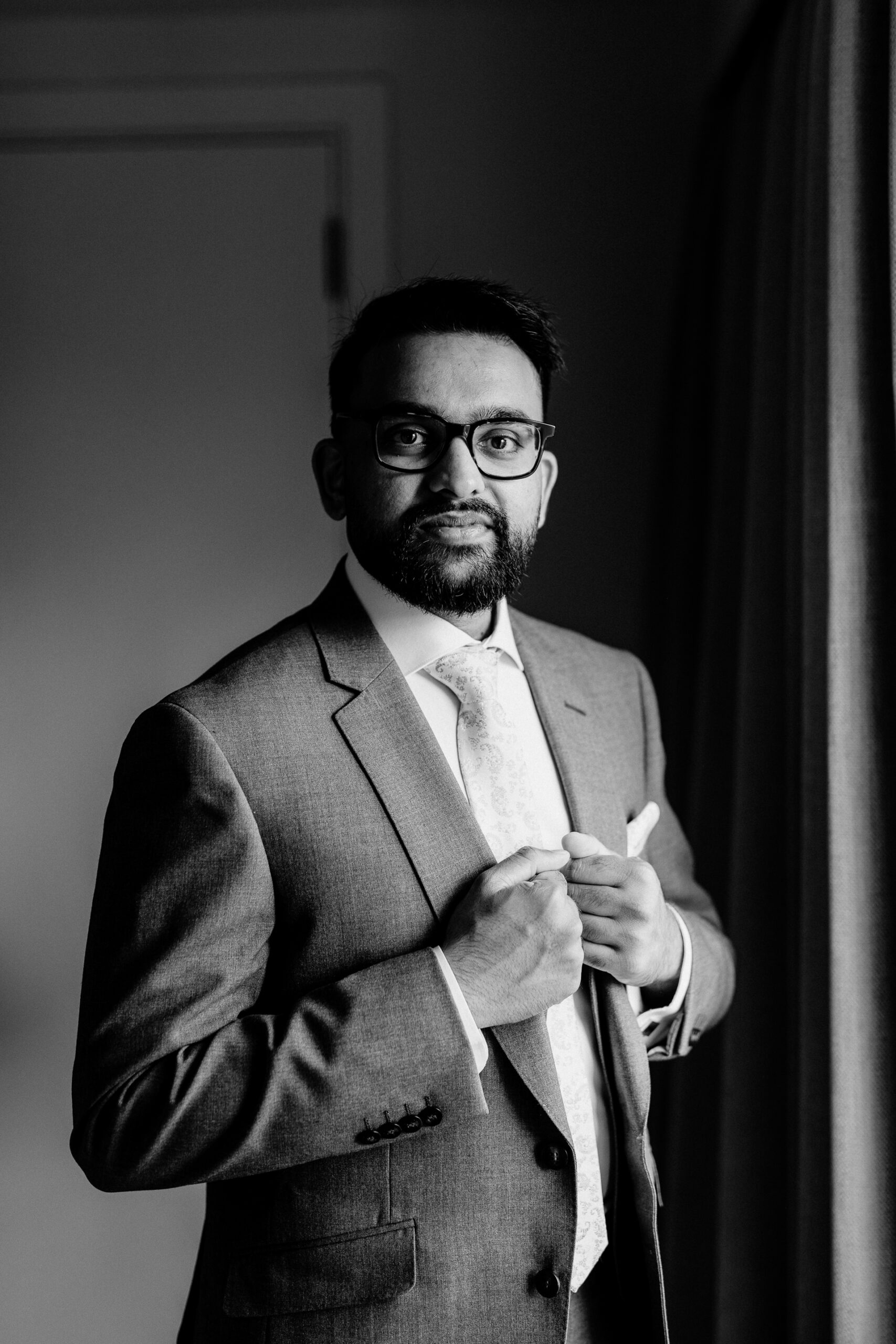 A man wearing glasses and a suit