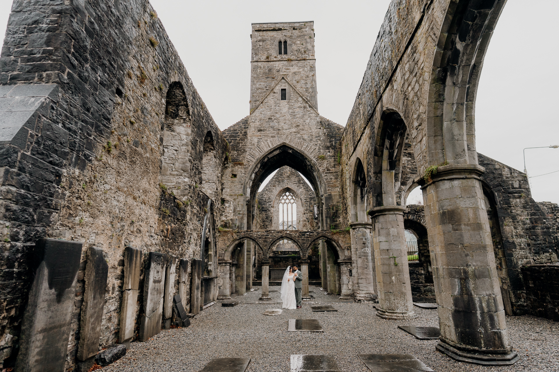 A couple of people standing in a stone building with a tower