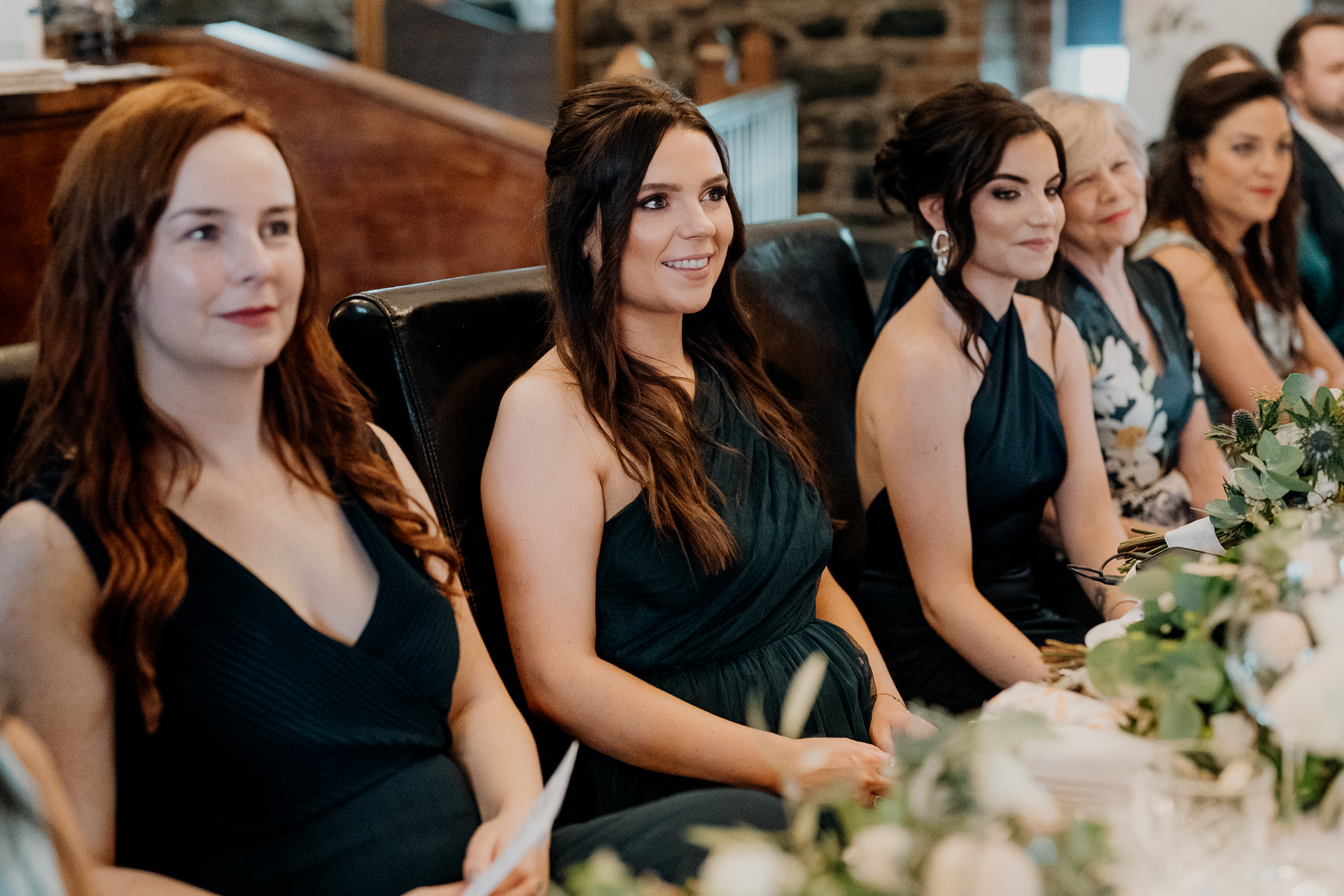 A group of women sitting at a table with flowers