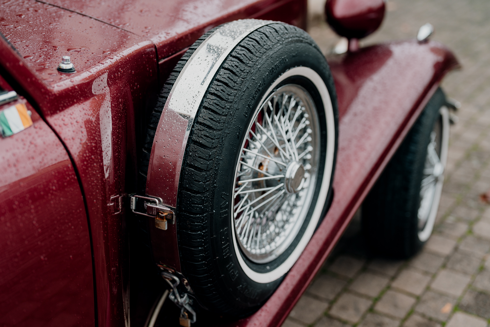 A red car with a black tire