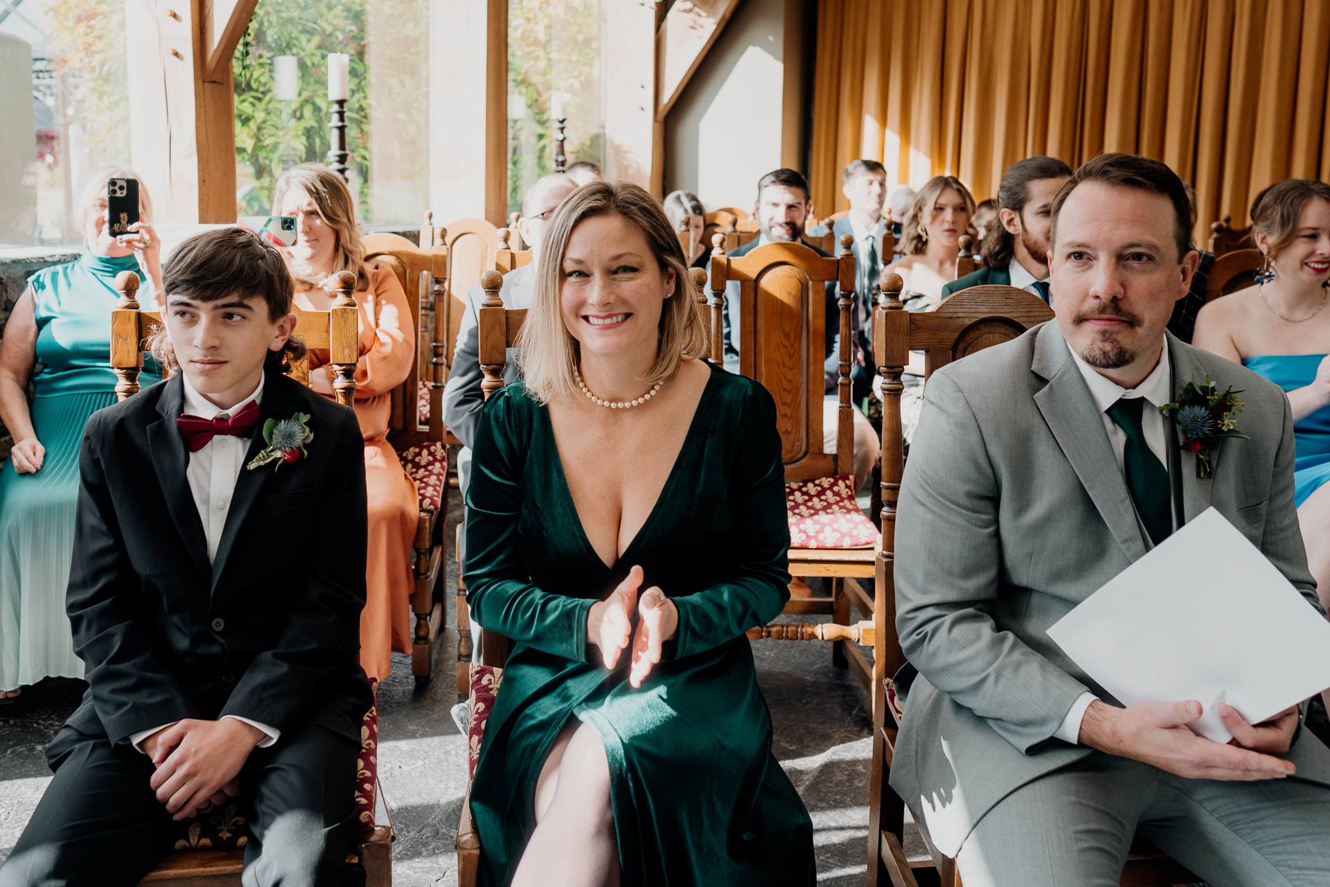 A man and a woman in formal wear sitting on chairs