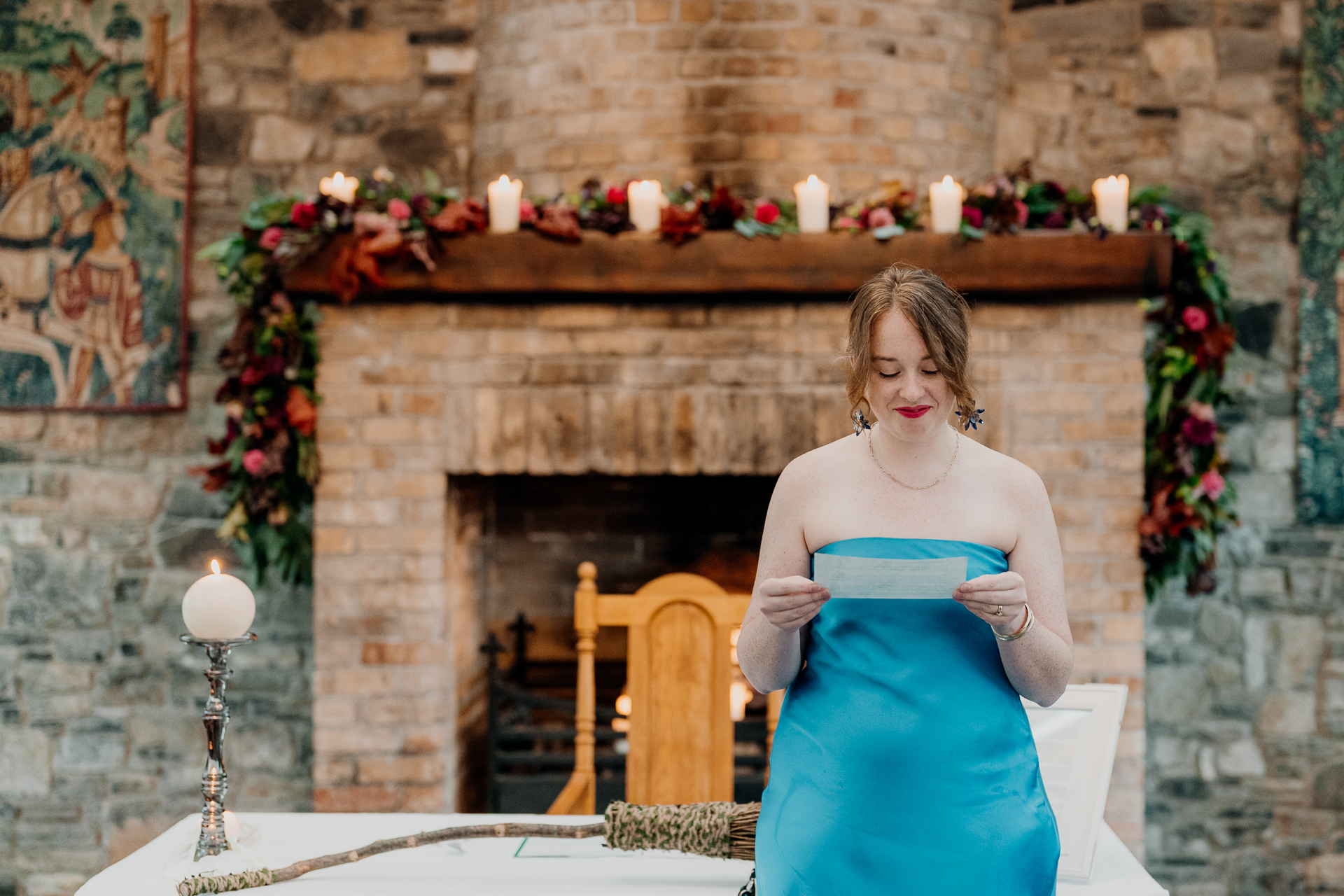 A person in a dress standing in front of a fireplace