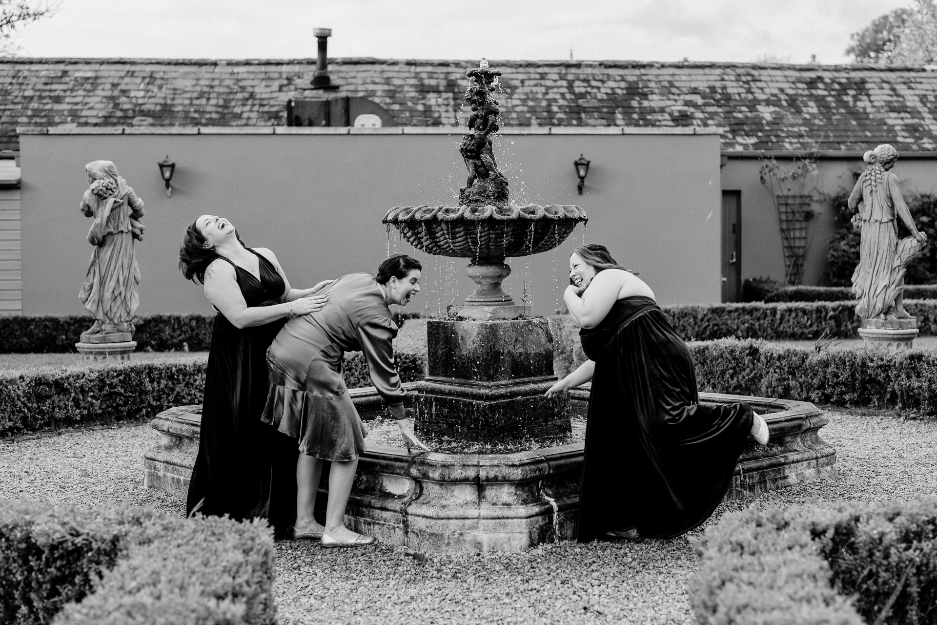 A man and woman kissing in front of a fountain