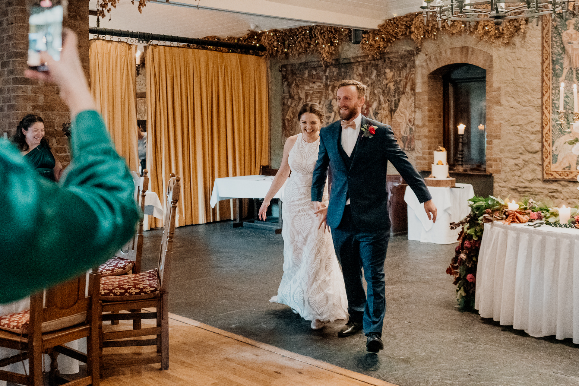 A man and woman walking down a hall with a table and chairs