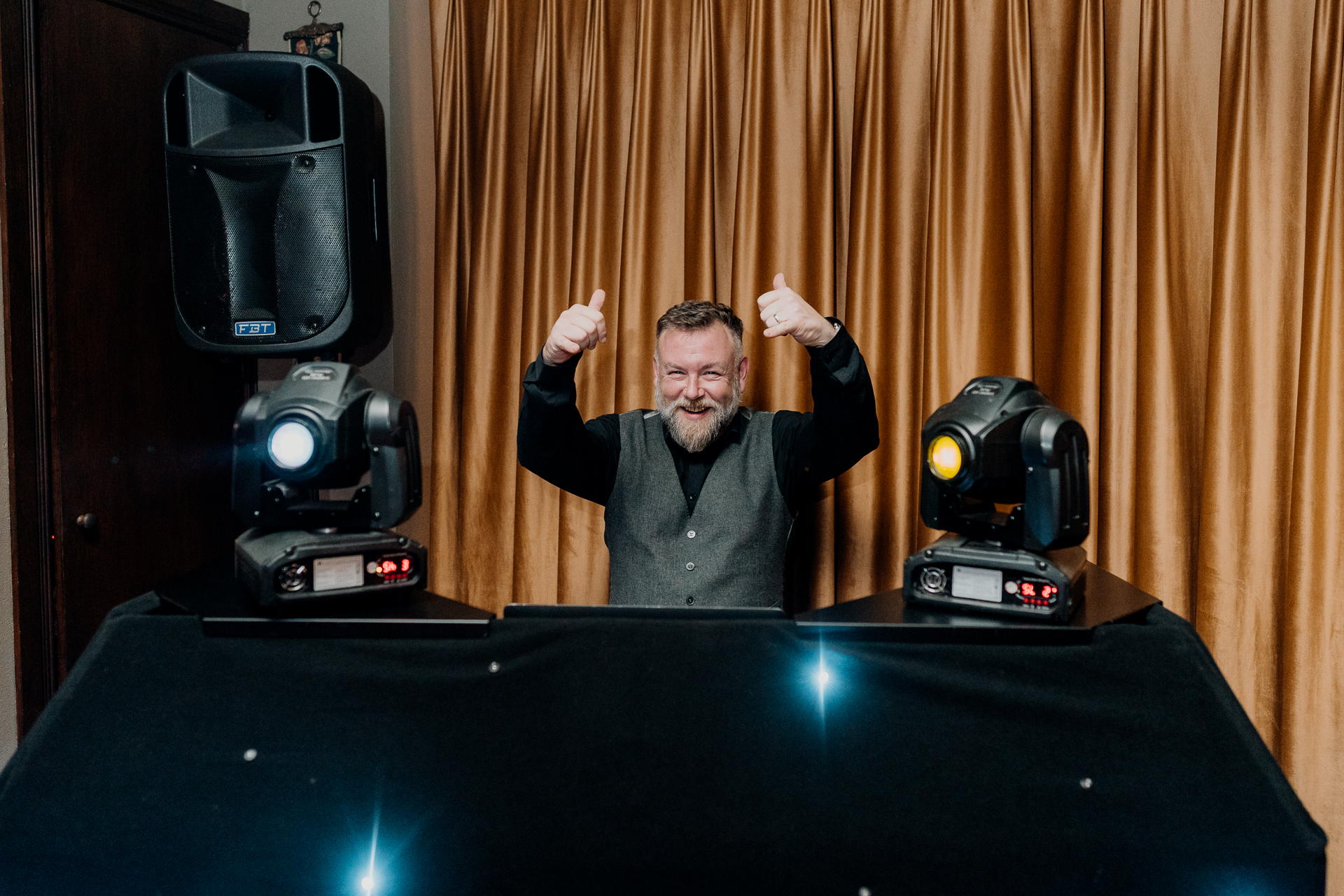 A person with the hands up in front of a podium with speakers