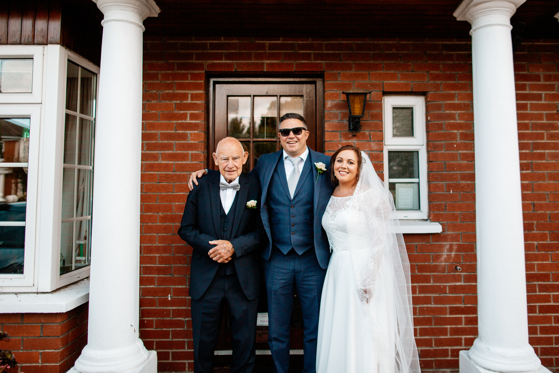 A group of people posing for a photo in front of a brick building