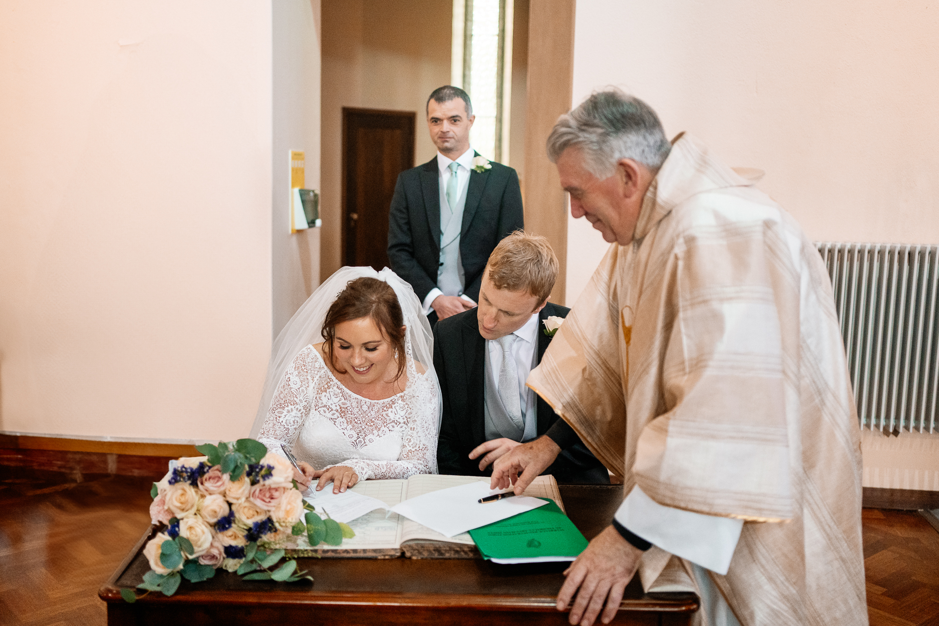 A group of people standing around a table with a person sitting at a table