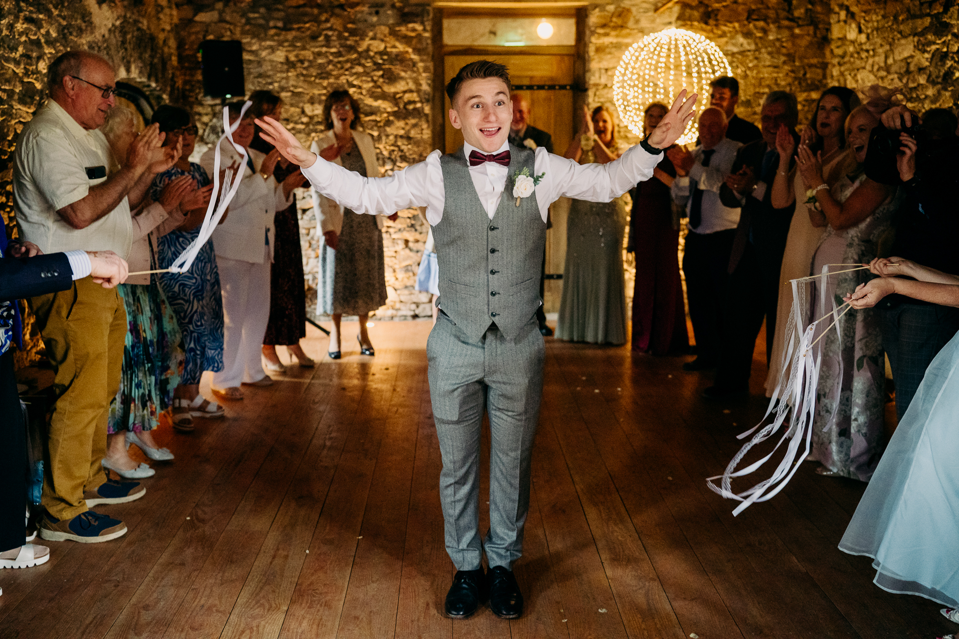 A person in a tuxedo dancing in front of a group of people