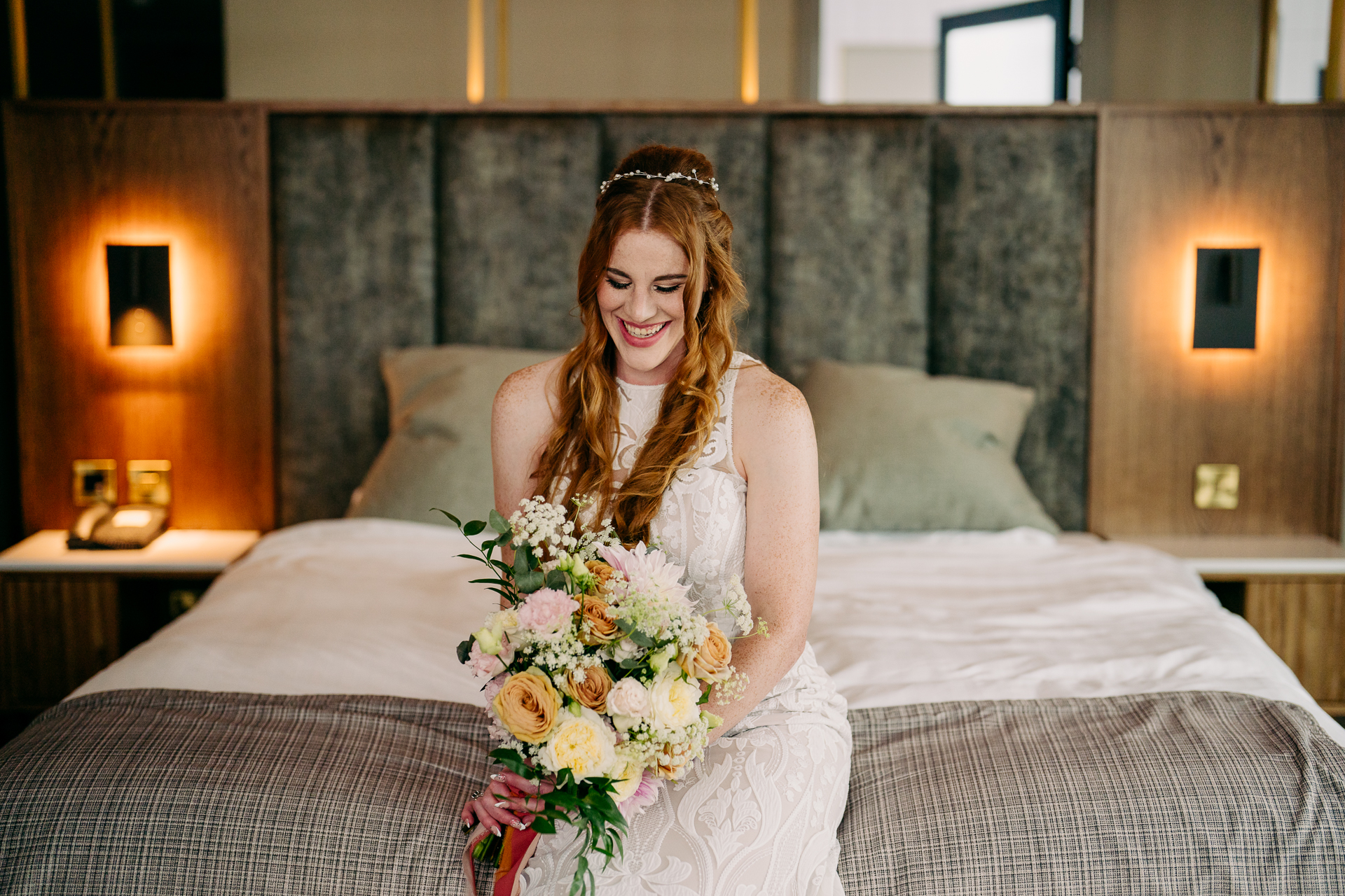 A woman in a white dress sitting on a bed