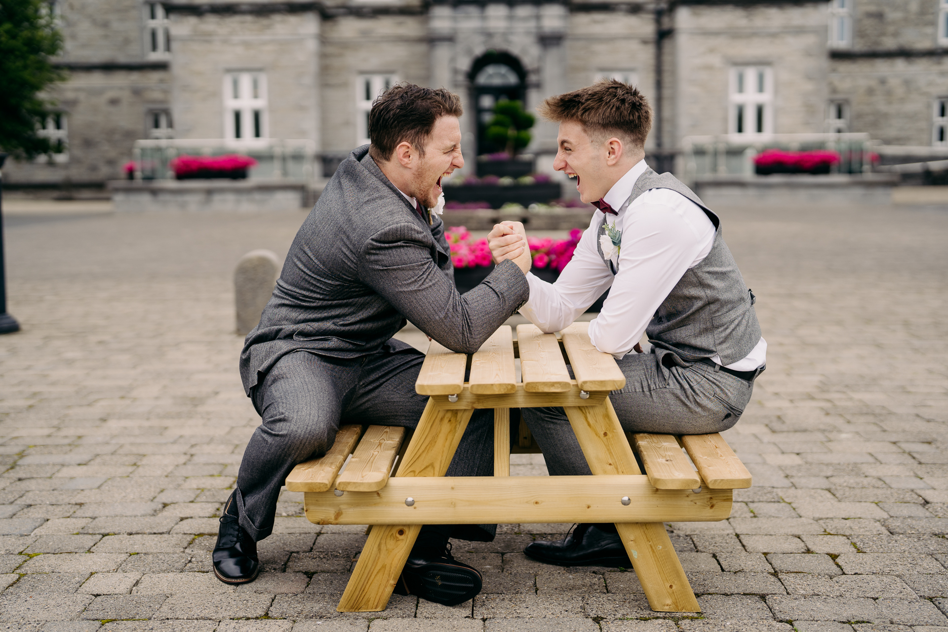 A man sitting on a bench next to another man