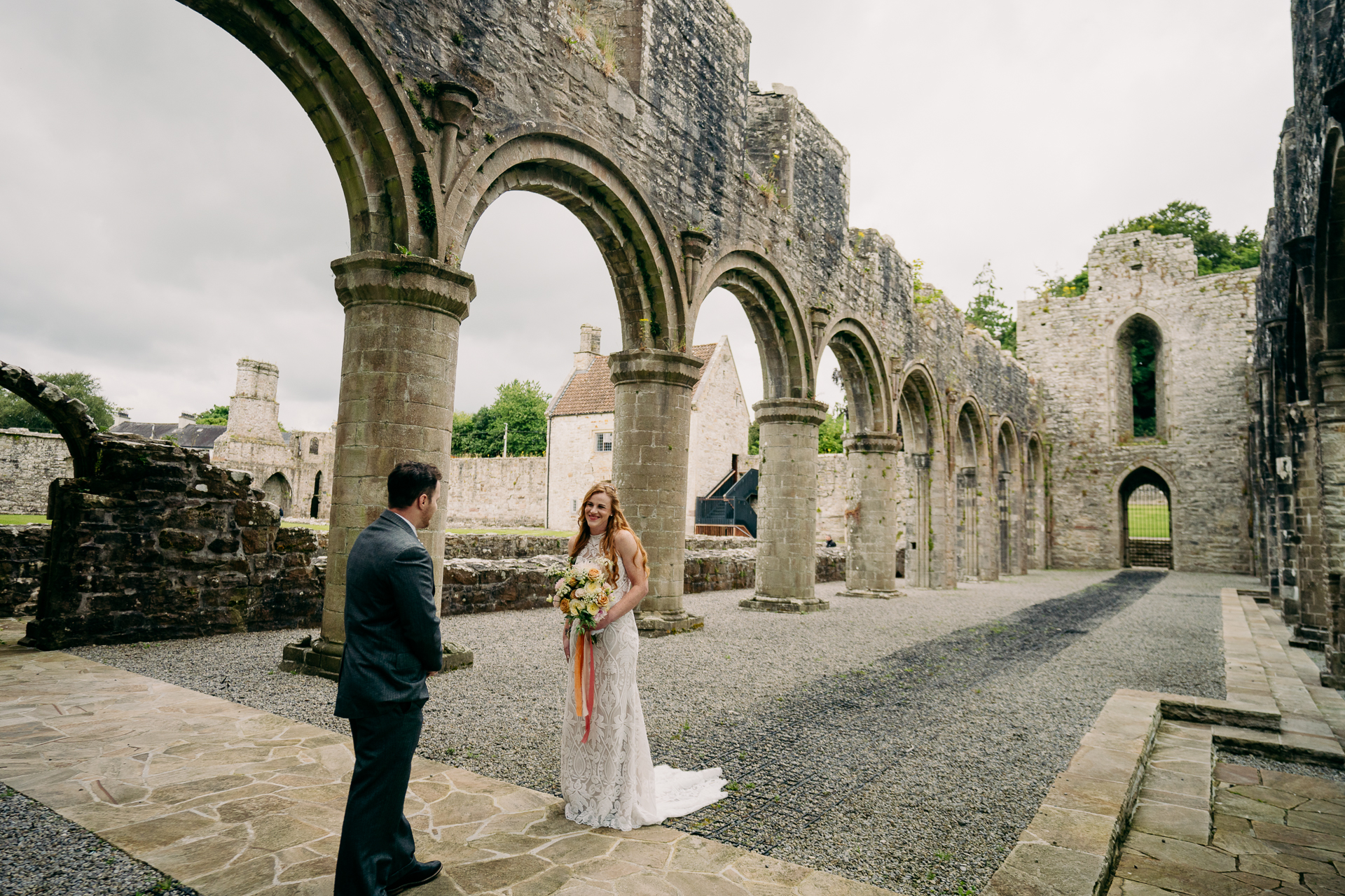 A man and woman in a stone courtyard with a building in the background