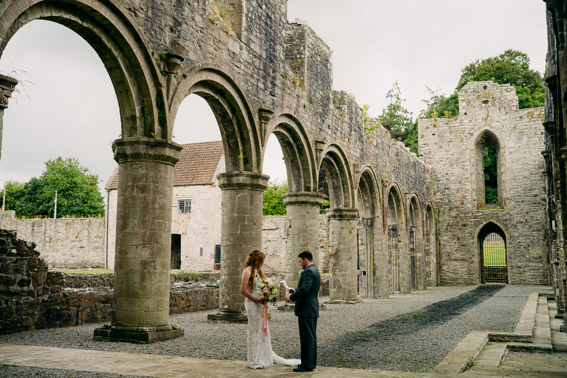 A man and woman kissing in front of an old building