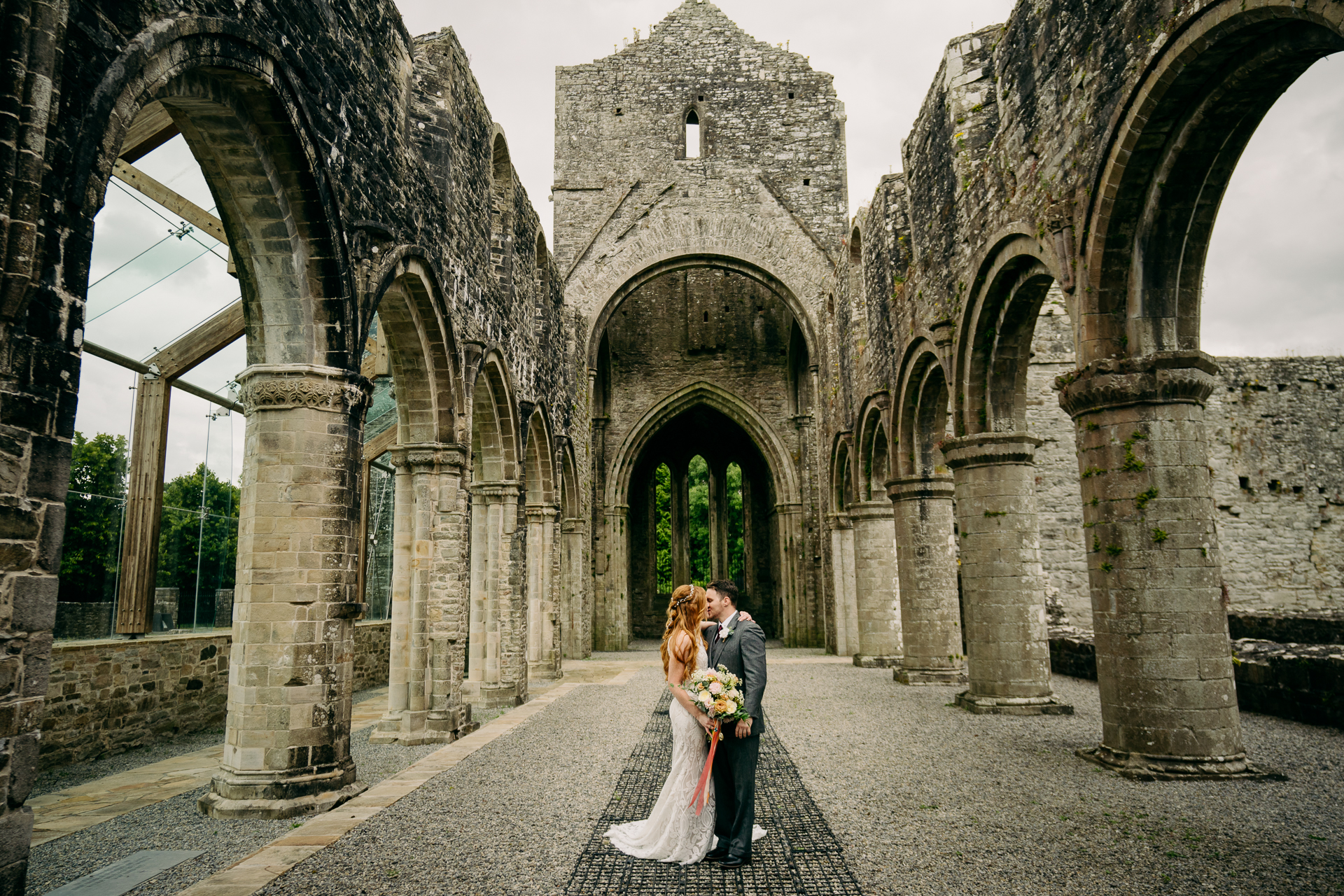 A man and woman kissing in front of an old building