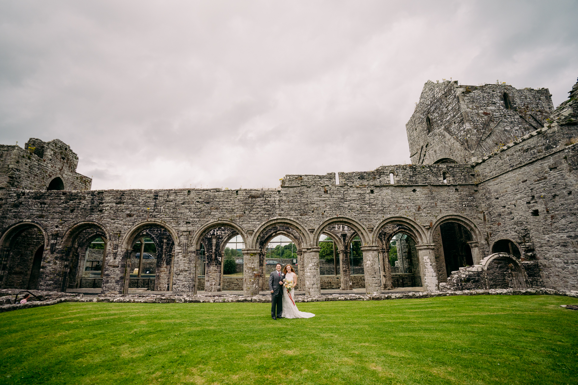 A bride and groom in front of a stone building