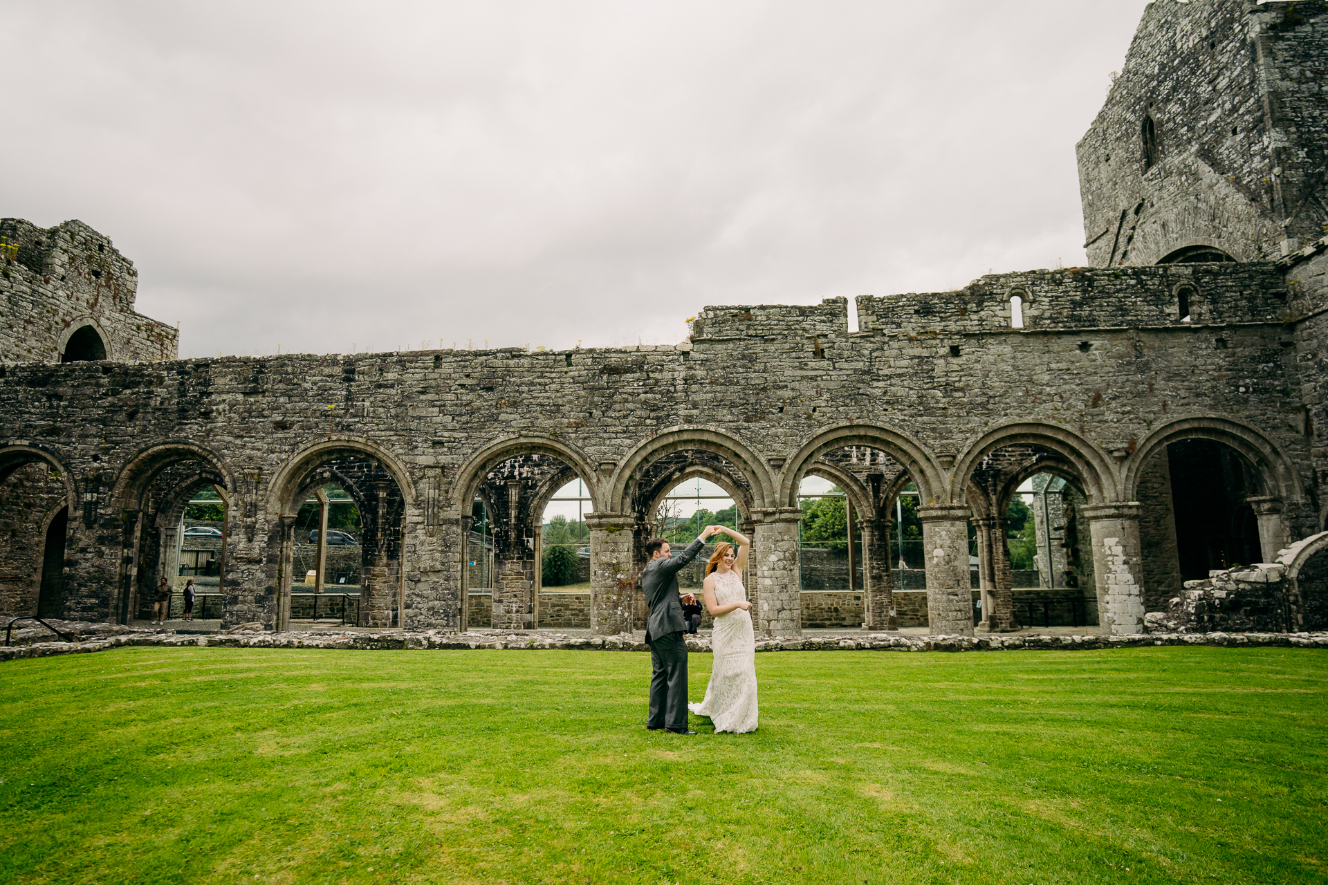 A man and woman standing in front of a stone building