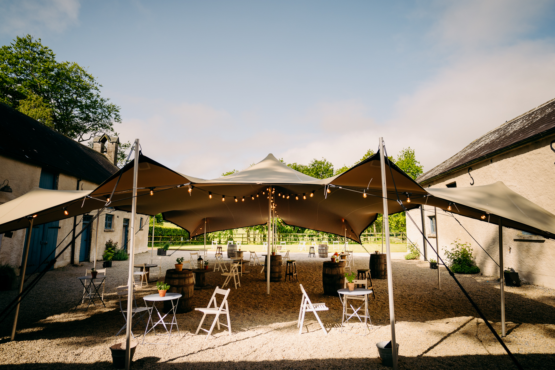 A group of tents with tables and chairs outside