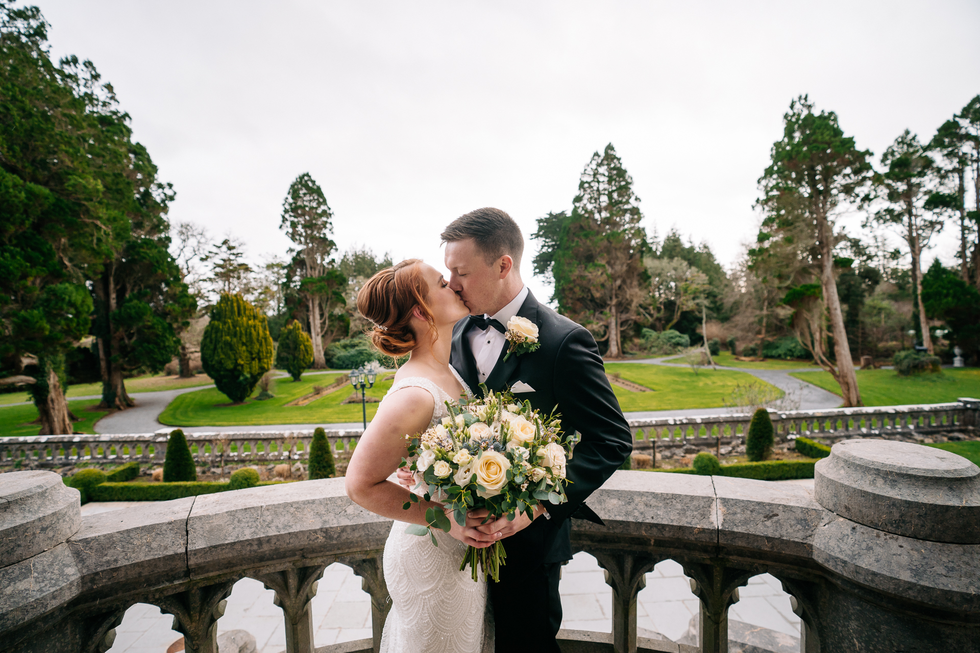 A man and woman kissing on a bridge