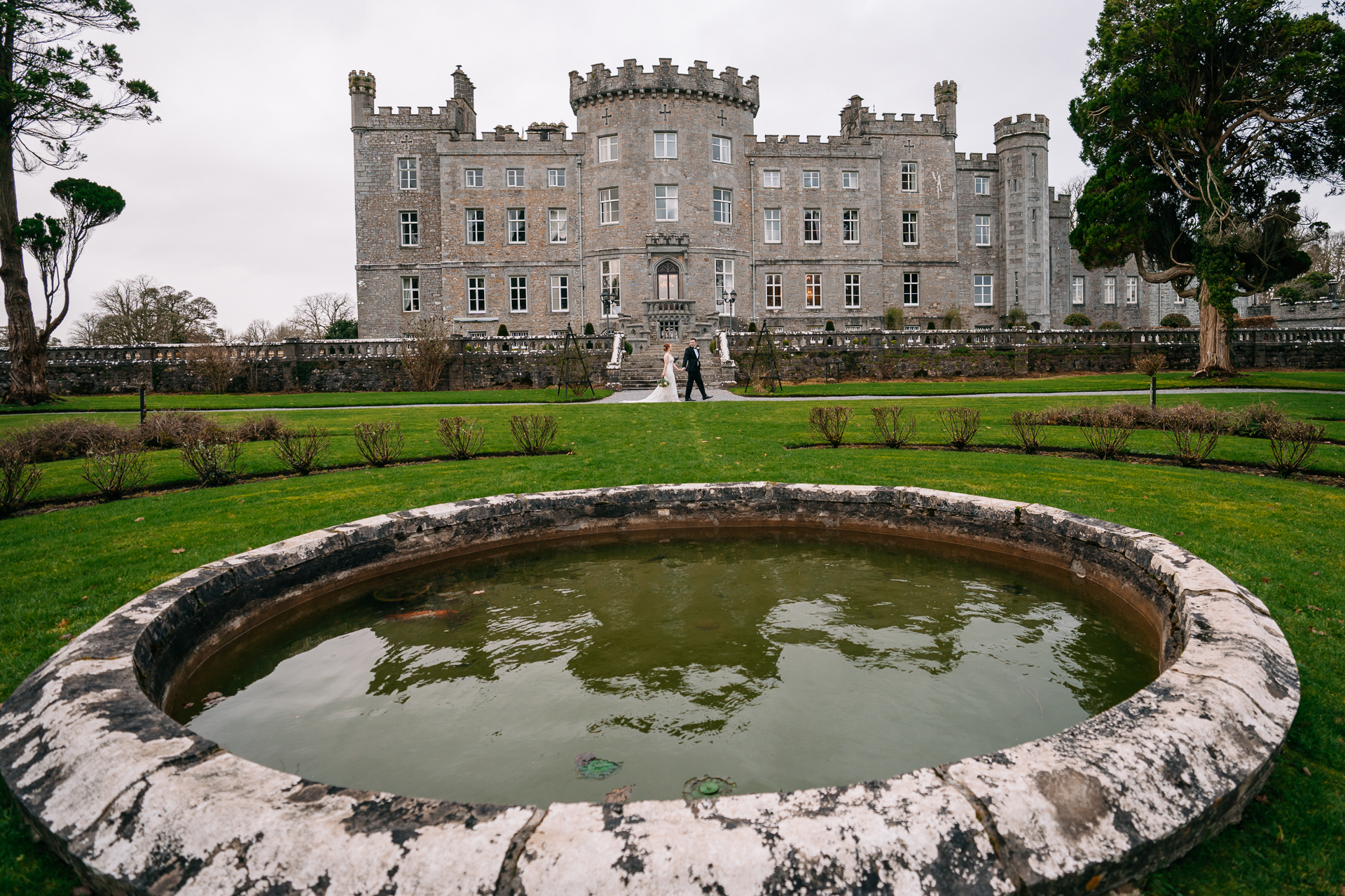 A large building with a pond in front of it