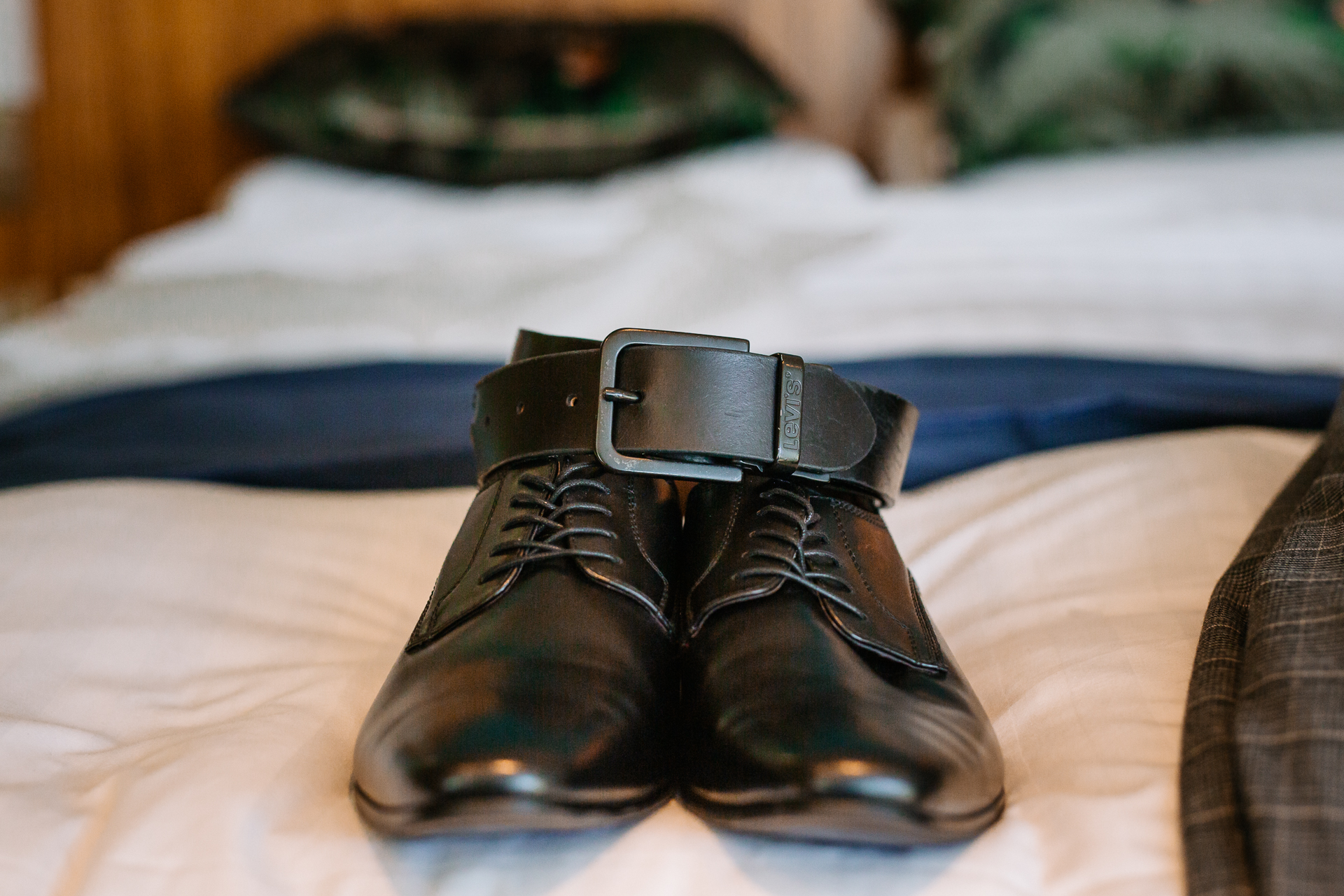 A pair of black shoes on a bed