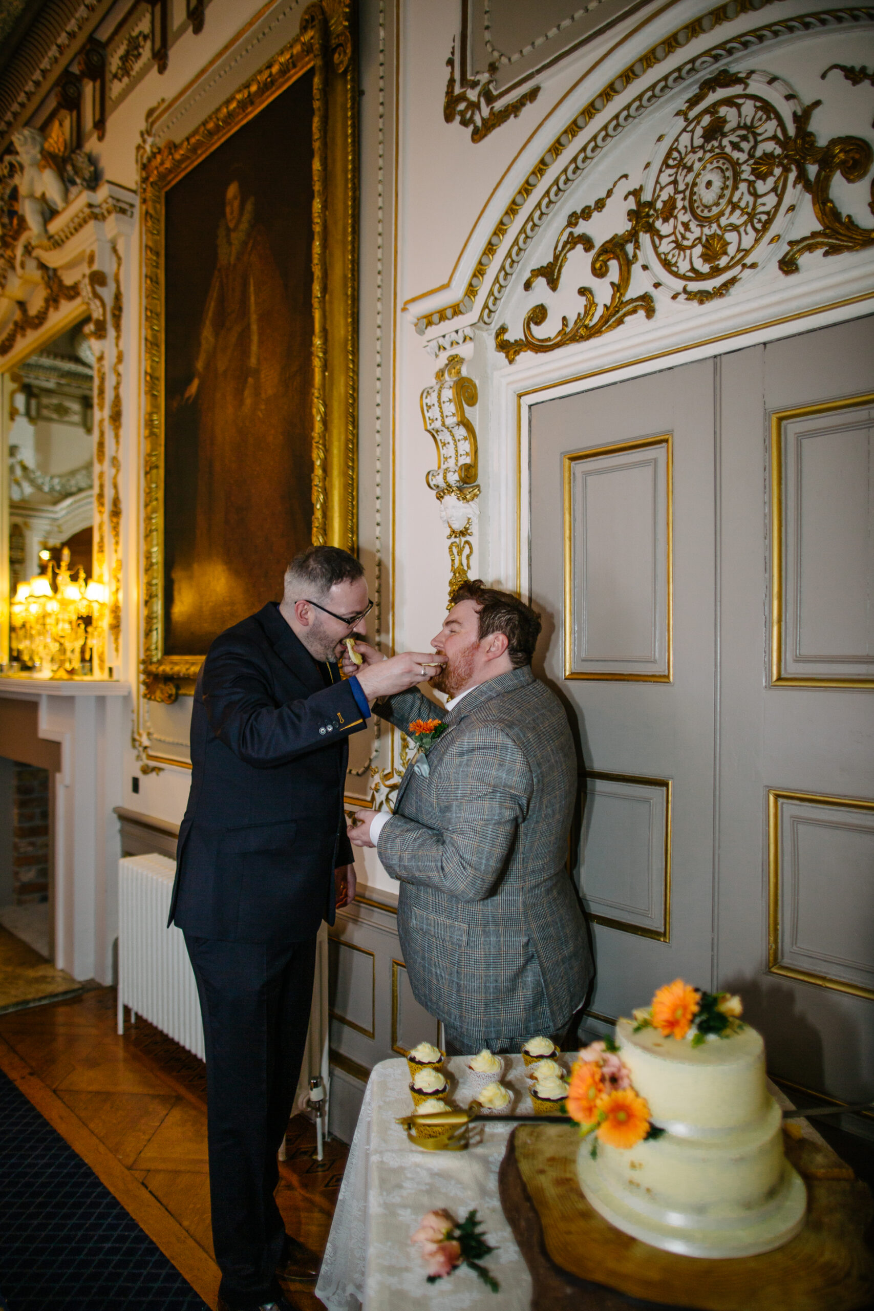 A beautifully decorated wedding cake and the cake-cutting ceremony of two grooms during their LGBT wedding at Markree Castle, Ireland.